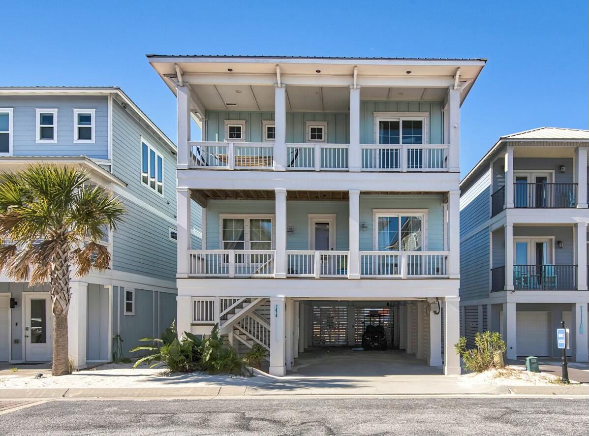 STUNNING WATER VIEWS! Discover coastal luxury in this custom home located in Navarre Beach's exclusive By the Sea gated community. Just steps from the Santa Rosa Sound, this property offers resort-style living with access to a sparkling community pool and hot tub. Inside, an open floor plan is filled with natural light from wrap-around windows and 10' ceilings, creating a welcoming and elegant atmosphere. The living area features sophisticated furnishings and a cozy fireplace, while the modern kitchen boasts granite countertops, stainless steel appliances, and ample space for cooking and entertaining. The first floor includes a queen bedroom, a bunk room, and a convenient half-bath, while the second floor features a luxurious primary king suite with a spa-inspired en-suite bath, soaking tub, walk-in shower, and private deck with breathtaking water views. Additional upstairs bedrooms include another king room with deck access overlooking the Sound, a bunk room, and a shared full bath. Outside, a private oasis awaits with a fully equipped outdoor kitchen with concreate countertops, fire pit, gas grill, flat-top griddle, refrigerator, seating areas for enjoying stunning sunsets, and a private gate leading to the Soundside beach, complete with an outdoor shower for easy cleanup after a day in the sand. This home is just a short drive to local attractions, including the pier, beaches, and scenic paths to the National Seashore Park, making it an ideal choice for a full-time residence, vacation retreat, or investment property. Whether you're looking for a permanent residence, a vacation getaway, or an investment property, this home offers the ultimate combination of comfort, style, and location. Don't miss your opportunity to own this turn-key coastal gem. 