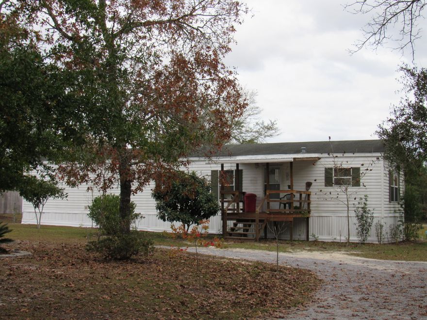 PRICED TO SELL! GREAT LOCATION! This beautiful home has been very well kept. It comes with a beautiful 1 acre lot, detached carport and a very nice workshop/yard building for storage. The front entrance features a circular driveway and there are new covered porches on the front and rear of the home. The beautiful landscaping is also in place featuring peach, apple, Japanese plum, and much more! There is plenty of room for a garden. This 2/1 home is spacious and is in excellent condition! This home is also pre-wired for a ''Generic Brand'' whole home generator and has a 300'' deep well! The kitchen comes complete with a refrigerator. The home is in great condition and is move in ready! Call for your tour today! It won't last long!