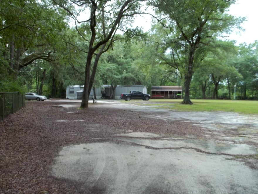 Nice 3 bedroom 2 bath home located on a beautiful 1 acre lot. The lot has many large oak trees. There are 3 sheds located on the property. One of the sheds is large enough to make another small home. Behind the home is a fish cleaning sink. This lot offers plenty of privacy and room to build your dream home. There is a private well pipe but no pump or tank. The entire lot is fenced in with chain link fencing. Buyer to verify all matters of importance.