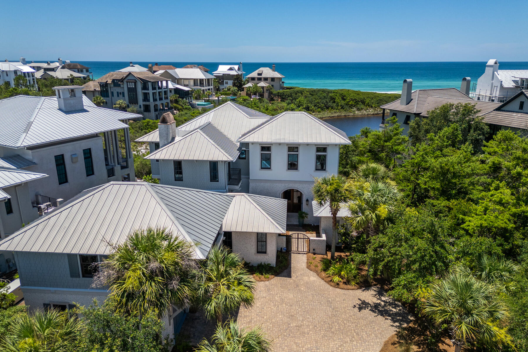 201 Bermuda Drive is located in the exclusive private gated neighborhood of The Retreat on 30a. Incredible views of both the Gulf and Draper Lake merges the outdoor beauty with that of the interior beauty consisting of custom fine finishes, high ceilings, pleasant decor, and natural light. The home has a total of 8,243 sq.ft. consisting of 5,558 sq.ft. of heated/cooled space, balconies, and an outside sitting area with fireplace. The heated/cooled spaces consist of the main house, a detached one-bedroom guest quarter, and separate Carriage House. The welcoming foyer opens to the second level of the home with an open floor plan consisting of the gourmet kitchen, gathering room with fireplace, balcony, half bath, and laundry area. Take the elevator or stairway to the 3rd floor or the ground floor. Out the kitchen door is the outdoor sitting area with fireplace, entry to the one-bedroom separate guest quarter with private bath, grill area, and exit to fenced yard. The outside staircase leads to the charming Carriage House with bedroom, bath, kitchen and sitting area. The third floor hosts the spacious master bedroom suite with sitting area, master bath suite with oversized walk-in shower, large walk-in master suite closet, and the 3rd floor balcony. The 3rd floor also contains a guest room with full bath, a sitting/break area with fridge and sink and a viewing balcony, and the 3rd floor laundry area. Ground Floor opens to the sitting area and boasts two bedrooms with Jack and Jill bath, ?? bath, and exit to the pool area.  The property is fenced and is excellent for the family dogs to visit the outdoors. Exterior features of the home include coquina shell stucco, decorative fencing, pool area, landscaping, and an outdoor courtyard shower after a day on the beach. The home is just steps away from The Retreat's private beach and Coastal Dunes. The Retreat is a non-short term rental community with a guarded gated entry, a luxury community pool and clubhouse area overlooking the beautiful Gulf of Mexico, and of course near 30A restaurants, biking, shopping, and golfing.  Buyer to verify all dues and dimensions.