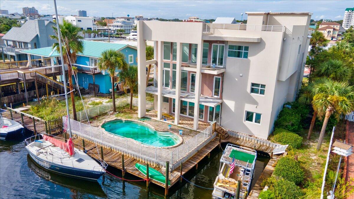 *Under contract, seller taking backup offers* Investors DREAM, in need of renovations! Executive 3 story waterfront home in Holiday Isle offers over 6,000 sq ft of heated and cooled living space, rooftop patio with glimpses of the Emerald Coast, deep-water boat-slip with additional dock space for a 2nd boat, and an in-ground swimming pool for those hot summer days! Your next home offers 80' of canal water frontage and is only a 5 minute boat ride to Crab Island or 2 miles to harbour front dining. With all of the exquisite indoor and outdoor living space, entertaining is guaranteed to be a breeze! As you enter the ground level you will find a living area or game room and a full bedroom and bathroom, with a backdoor that leads out to the pool deck - perfect for pool parties.