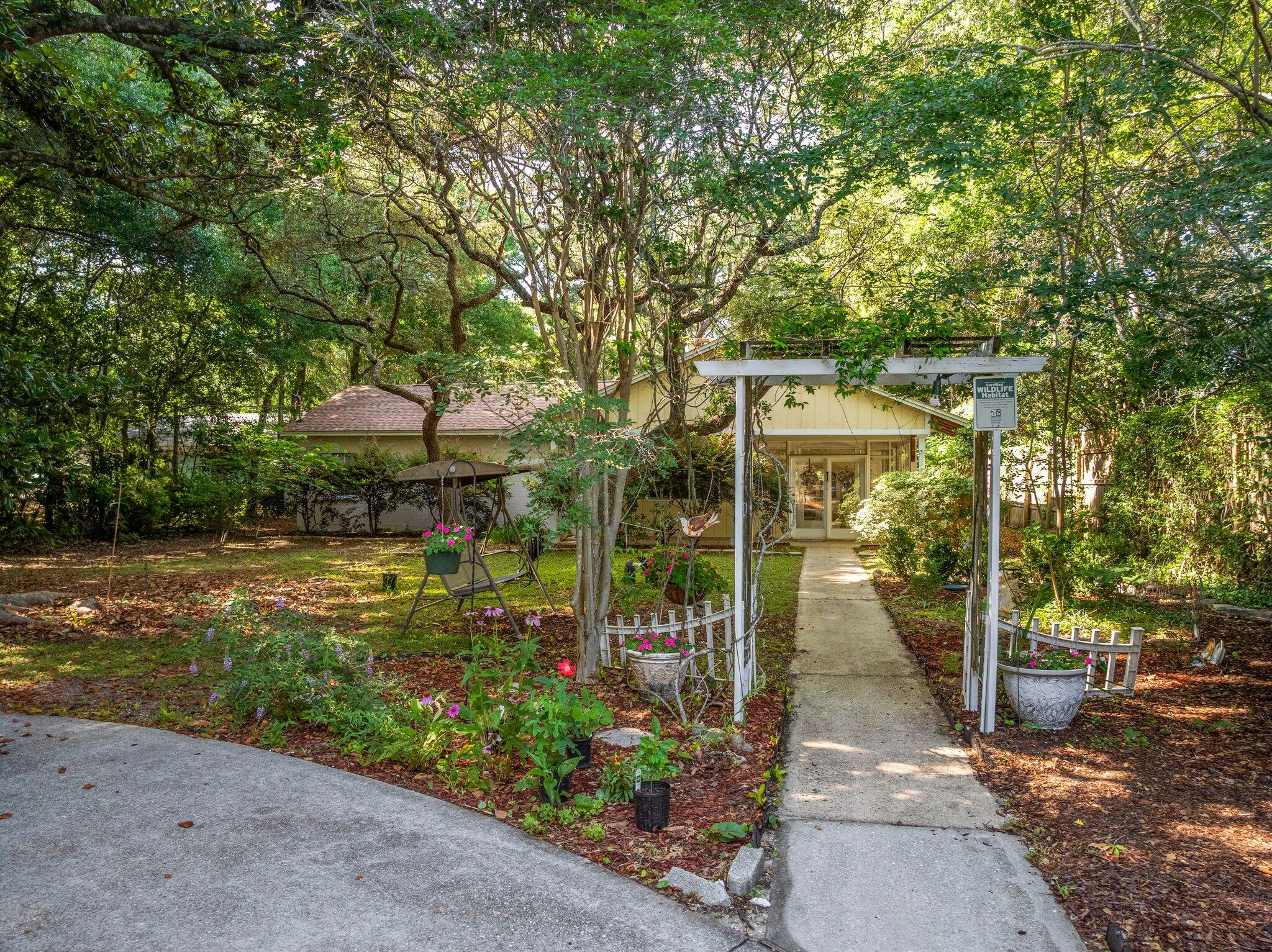 Charming Nature Retreat in Fort Walton Beach *** Discover serenity in this beautifully unique home, nestled on a spacious 0.48-acre Certified Wildlife Habitat lot. Surrounded by mature trees, lush gardens, and vibrant wildlife, this 3-bedroom, 2-bath retreat offers vintage charm with some modern updates--all conveniently located to military bases, shopping, restaurants, schools, medical, and beautiful beaches. *** A circular driveway leads to a welcoming arbor-covered walkway and a covered front porch with exposed beams. Inside, the Florida room is bathed in natural light--perfect for relaxing or entertaining. The spacious living and family rooms provide inviting spaces, including a cozy wood-burning fireplace. The kitchen, with warm wood cabinetry and exposed brick, opens to a bright dining area with parquet floor and backyard views. Step outside to enjocovered porch, an open patio, greenhouse, storage shed, and flourishing gardens featuring live oaks, herbs, flowers, and fruit-bearing plants.***Recent updates and features include: new roof (2021), water heater (2018). A transferable home warranty is in place. In addition, the home is equipped with copper wiring and has undergone a 4-point inspection (August 2024) and wind mitigation assessment (August 2023), with reports available upon request.***Original brick wood-burning fireplace, 4x4 tilework in bathrooms and timeless details throughout make this home truly special. A rare blend of charm, space, and nature in the heart of Fort Walton Beach. *** Schedule your showing today to experience this hidden gem. *** Buyer is responsible for verifying all data and information including lot size and room measurements as it is deemed to be reliable but not guaranteed.