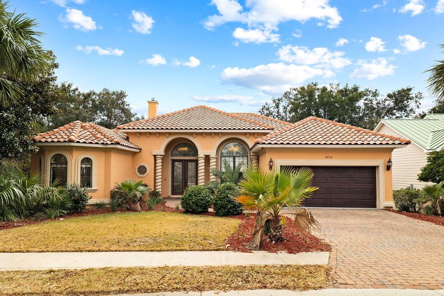 Upscale and impeccably maintained, this single level Mediterranean-inspired home is situated in the sought-after gated community of Destiny East.  Characterized by an expansive and efficient footprint with intricate details from soaring 12' ceilings with stacked crown molding to tile and wood floors, this custom-built home offers a desirable floorplan for personal use or as a vacation rental.  Ample living space with ornate millwork, niches, and a finely appointed finish level is highlighted by the formal dining area, a large kitchen with detailed cabinetry and breakfast bar, and 2 living room areas with a sitting area overlooking the pool in the backyard. Offered fully furnished with pieces selected by a local designer, the split-bedroom design offers privacy with the master suite standing alone on the left side of the floorplan.  Desirable touches include a fireplace in the master bedroom, a trayed ceiling with lighting and ensuite master bath with separate vanities, soaking whirlpool tub and separate steam shower.  2 walk-in closets flank the arched-hallway leading into the master bath.  Directly adjacent to the second living area is the guest suite with 2 guest bedrooms and a shared bath, and a walk-through laundry room from the kitchen leads to the 2-car garage, which houses an emergency generator.  Large windows with stained glass casing the main living and dining areas allow natural light to flow through for an open and inviting feel.  Two large sliding glass doors from both living spaces empty out onto the oversized covered porch that wraps around the heated pool and spa, with the entire area screened in and ready for entertaining.   