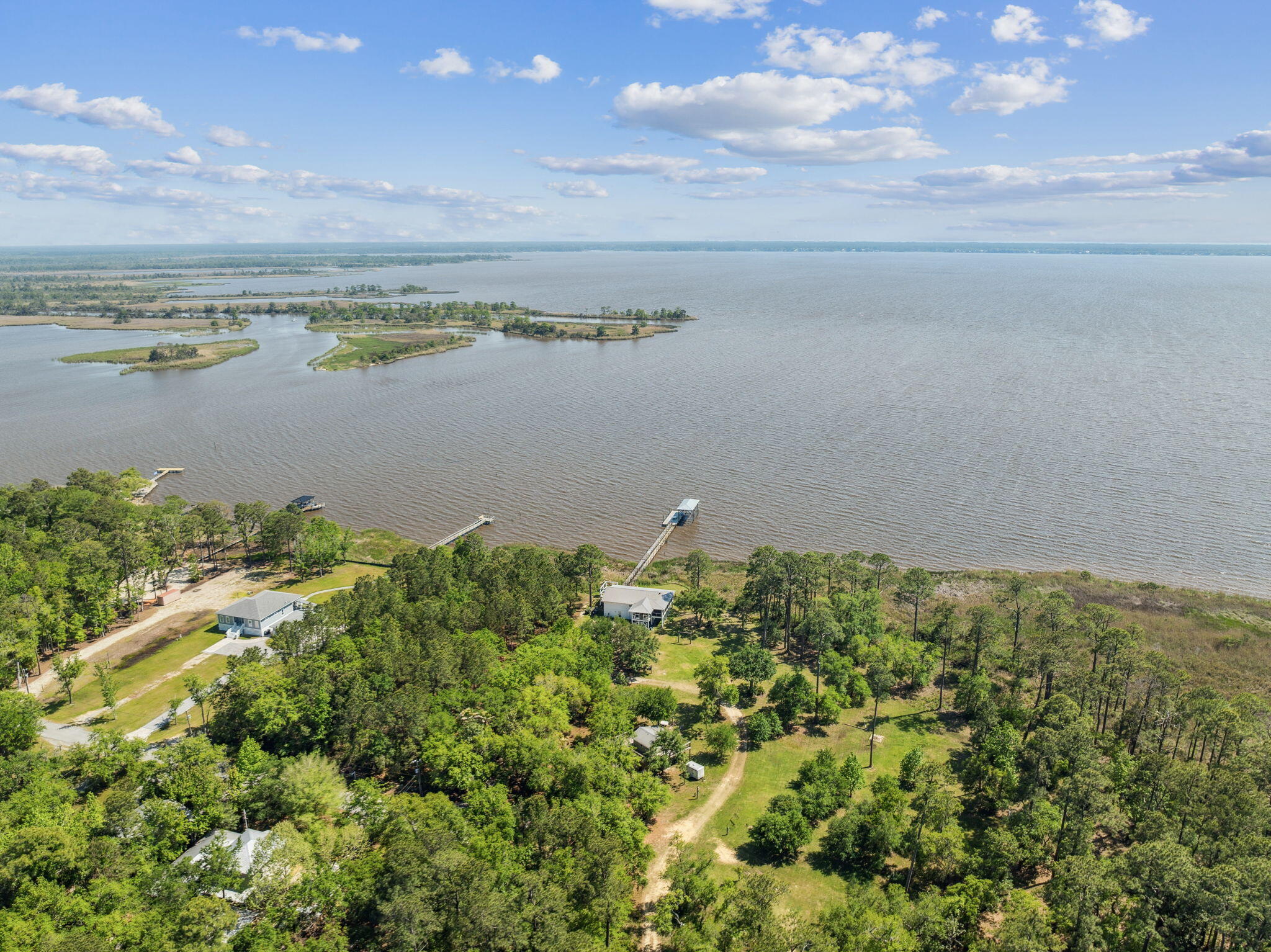 Seize the rare opportunity to own 1.77 acres of pristine bayfront property, offering breathtaking sunrise and sunset views over the water. Tucked away in a peaceful cul-de-sac, this expansive lot provides a serene and private setting, perfect for building your dream waterfront retreat.With over 200 feet of direct bay frontage, the property is ideal for boating and fishing enthusiasts, offering easy access to deepwater adventures. Surrounded by natural beauty, enjoy daily sightings of dolphins, soaring eagles, and other coastal wildlife. Adding to its value, the lot includes a tiny home, providing an immediate living space or guest accommodations while you plan your custom build. Whether you envision a luxurious estate, a charming coastal cottage, or an investment opportunity, this bayfront property offers limitless potential.
The owners would prefer to sell this property in conjunction with MLS #974714 - 227 Shady Lane.