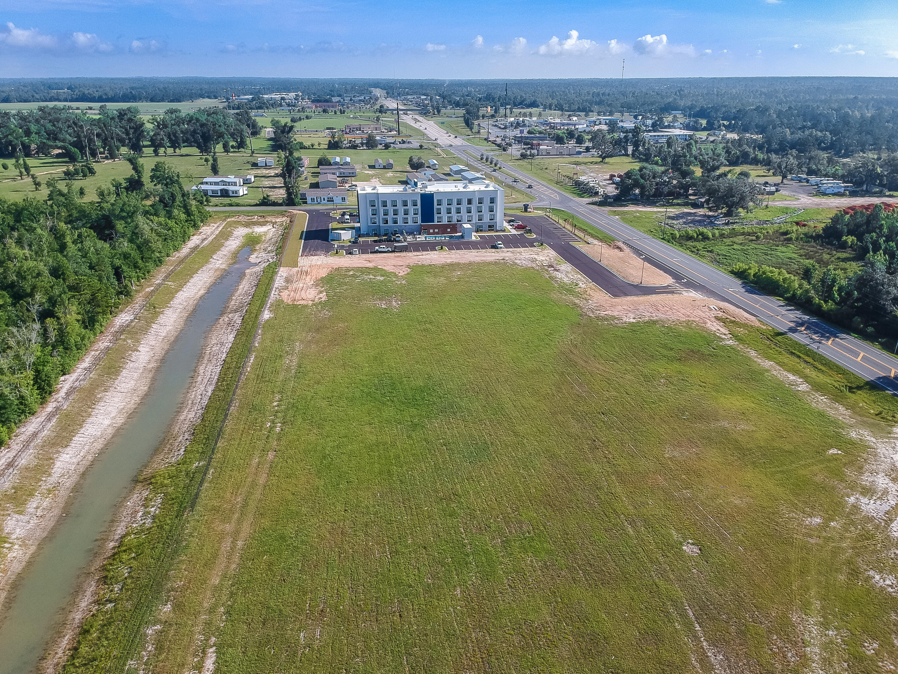 2 CLEARED and PAD READY Prime Commercial Lots for a total of 12.17 acres, which includes stormwater in place and water/sewer lines that run on both HWY 71 and Hope School Rd., and natural gas is available.  All utilities, including regional stormwater, are in place with common use driveways permitted and recently completed for access from both Hwy 71 and Magnolia Rd. The Magnolia Rd driveway entrance and the North Hwy 71 driveway entrance have both been completed and are now in use. The South Hwy 71 driveway entrance is permitted and ready for construction.  There is a 40-unit townhome project in the southwest corner of Hope School Rd, which is currently under review by the county and a development order in the works. There is also a newly constructed 4-story Hampton inn, adjoining to the north, that opened in May 2023, and 1500 feet from the new Chick-Fil-A that opened in April 2023. This parcel is less than a minute to I-10, which has well over 20,000 vehicles per day traffic count, and in the heart of Marianna, surrounded by big projects, and yours could be next!  This parcel totals 12.17 acres with approximately 2.5 acres of stormwater, leaving approximately 9.67 acres of 90% impervious development potential.  There are so many opportunities with this large parcel, and the hard work has been done for you.  There is an HOA, and documents are attached to the listing, but fees are not in place at this time. The HOA will transfer with the sale if the buyer would like.  An agreement is in place for shared drainage and easement maintenance based on pro-rated ownership with the hotel and town home community.  The seller has conceptual drawings for a strip center, and QSR restaurant as well as site drawings, original 14 acre survey (included hotel/townhome...not included in this sale), original topo survey elevations, HOA agreement, site plans for this lot, as well as the hotel and townhome parcel, original set of approved stormwater, driveways and utility plans, , and even a phase I environment report (dated 2006), which they are willing to share with a serious buyer with a signed NDA agreement. This area is home to many commercial businesses with a diverse range of industries and makes an ideal location for any new business and ready for your creative touch. If this sounds like the property you have been waiting for, make an appointment to view today before this prime commercial property is no longer available. All information is deemed reliable but must be verified by buyer via personal or formal inspections.