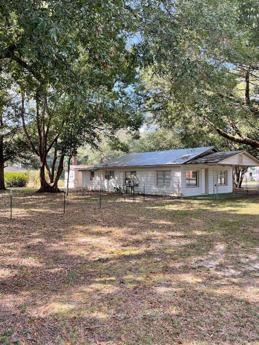 Opportunity for a great fixer upper on two lots. Affordable 3 BR, 2 bath home on corner lot in Defuniak Springs city limits.  Located just minutes from down town historic Defuniak Springs.  New metal roof only 3 years old and laminate floors throughout.  It's fully handicap accessible. beautiful old wood ceilings, big windows.  City water and sewer. Short walk to the elementary school and 3 local churches.  Large private shaded corner lot to add to or build later.  Beautiful mature trees on property. Schedule your showing today! Buyer to verify room dimensions.