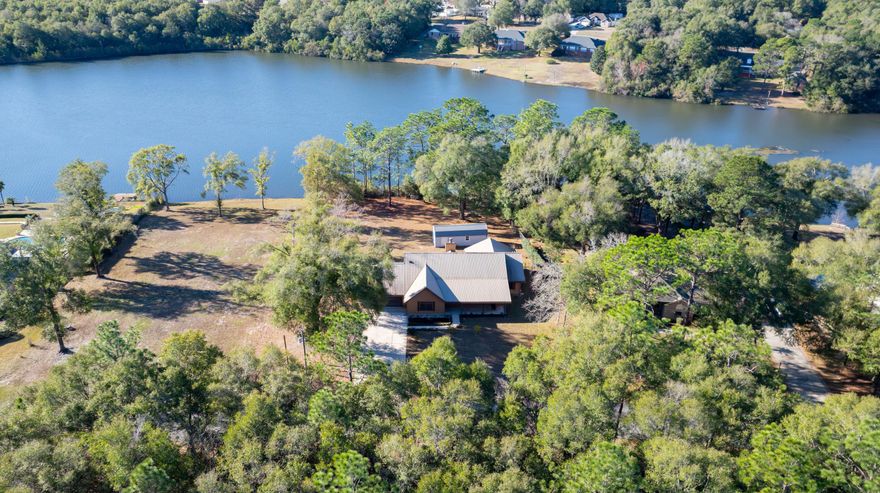 This is a first-time offering for this waterfront property priced to sell. The home is five minutes from downtown Crestview, located at 3066 Craig Terrace, a beautiful, quiet, well-appointed tree-lined street. This beautiful home is situated quietly on one of Crestview's largest lakes, spanning nearly 42 acres. Keep your John boat on your dock and go fish because this beautiful lake has Florida largemouth bass, blue channel catfish, bream, and crappie. You will enjoy watching the sunsets over the lake on the screened-in back porch. The property spans 1.66 acres with fruit trees, a large yard, and a custom shed measuring 12x32x12 with overhead loft storage. This home is a sprawling 2,130 square foot one-level ranch 3 bedroom 2 bath with a living room for a Home Office. The home boasts an oversized 2.5-car garage and a large driveway for six vehicles.  If you're looking for serenity, your search is over.
