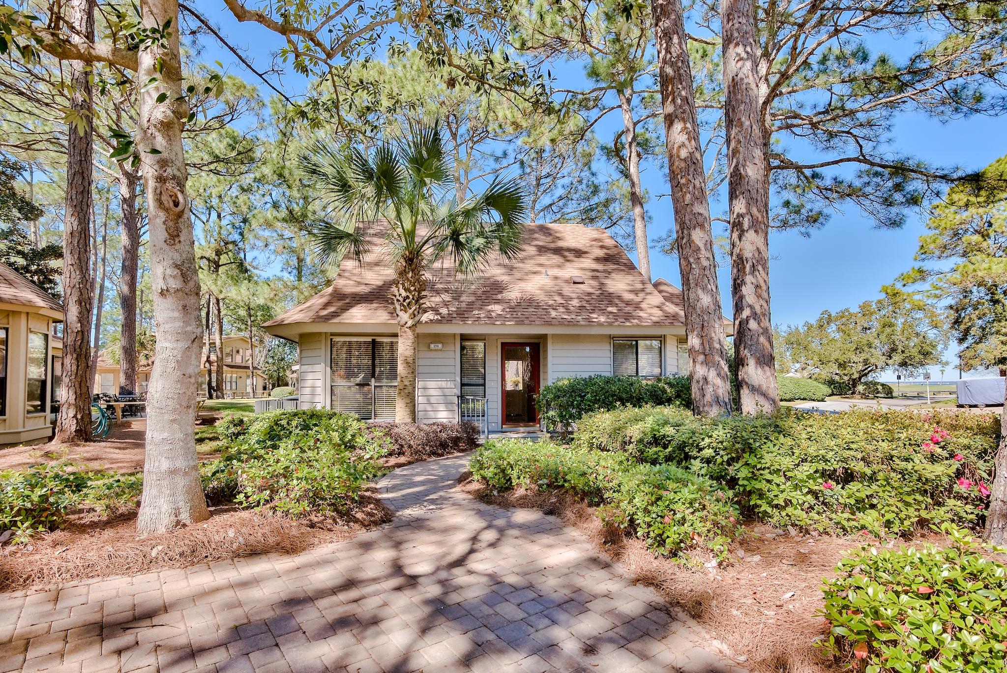 This lovely cottage is a rare find in the Fairways of Sandestin Golf & Beach Resort, a gated golf course community. Tucked away on a wooded corner lot, you will feel a sense of seclusion. This home is located just off the 8th tee box of the Links golf course. The large screened porch and deck provide a beautiful view of the 8th hole which ends dramatically at the edge of the Choctawhatchee Bay. Sunset views on the bay are spectacular and are a short walk from your back door. You are a short distance by car or golf cart from all of the fabulous amenities Sandestin has to offer. The owners have updated all plumbing in the house, and both the exterior and interior of the home have been freshly painted. Roof was replaced in 2016 and HVAC in 2013. The master bath was totally remodeled