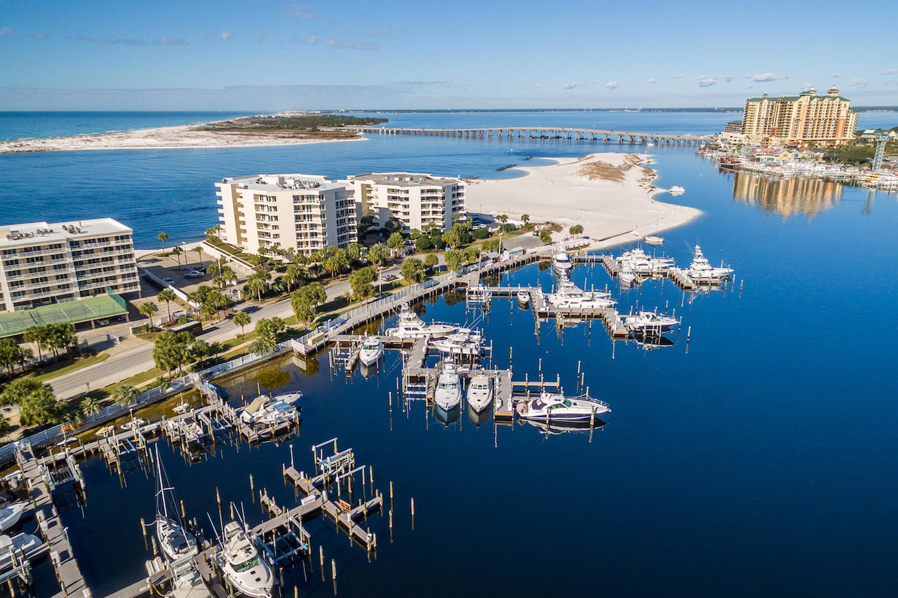 DEEP-WATER BOAT SLIP included! Beautiful fifth floor condominium with unparalleled views of Destin's jetties and East Pass with a boat slip on the scenic Destin Harbor! Floor-to-ceiling windows and a covered balcony run the entire length of the open living/dining/sitting room. A large pass through area to the kitchen and the wet bar in the living area make it an excellent setting for entertaining. The kitchen features an island, large pantry closet, lots of cabinets, and a brand-new stainless refrigerator. The split bedroom floorplan includes a bedroom with ensuite bath and dual sinks on each end, plus a smaller bedroom (or office/playroom/project room) and nearby bath. East Pass Towers II is a gated community on the western end of Holiday Isle which offers a private...