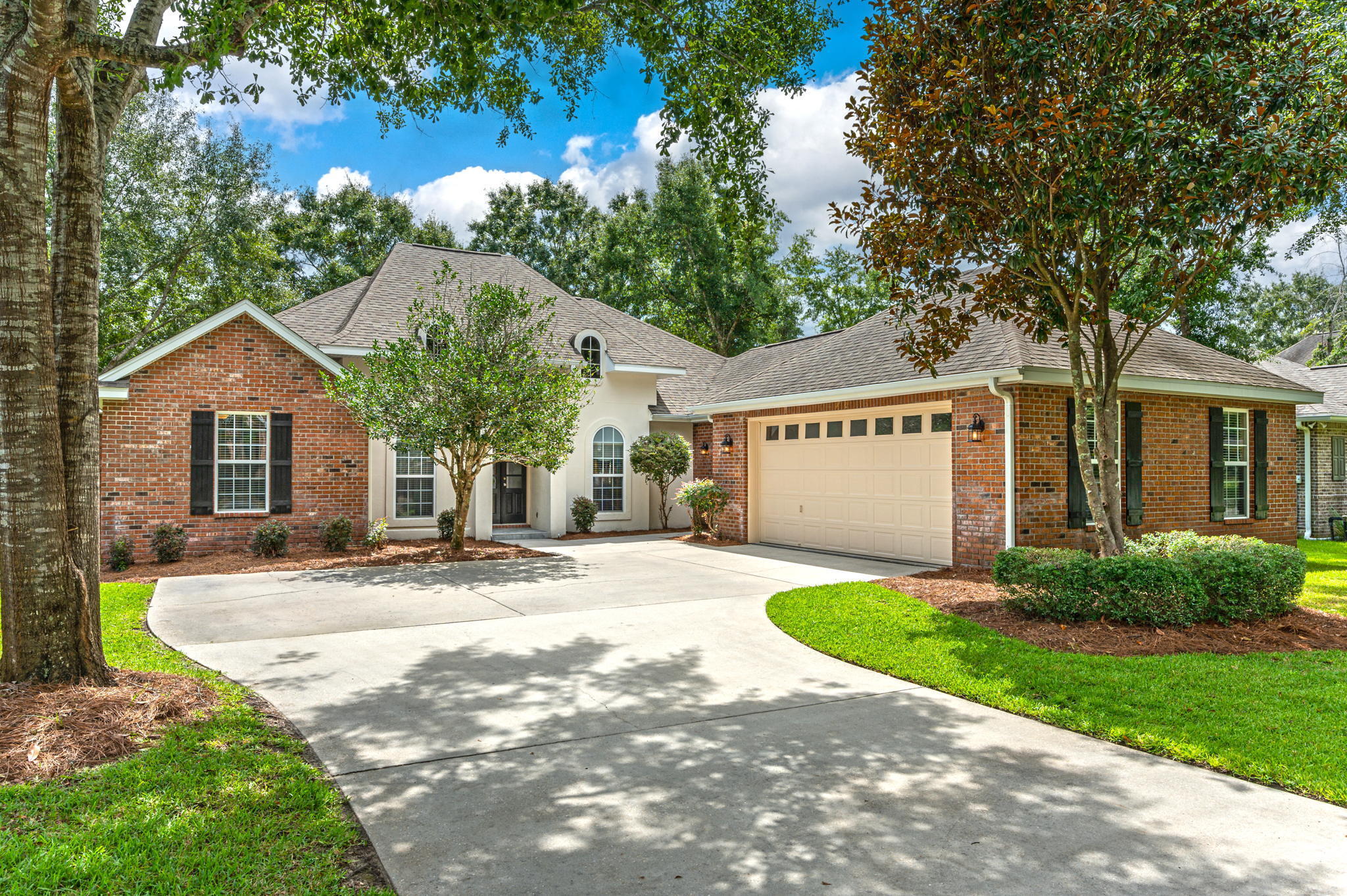 Situated in the quaint village of Claire's Vineyard, with its peaceful park-like setting, mature trees, sidewalks, streetlights and gated entrances for your privacy, this luxury custom built home is sure to appeal to buyers with the most discriminating taste. As you enter the home through the impressive 8' tall arched door into the formal dining and living room area, you are greeted by elevated ceilings, gorgeous porcelain tile flooring and one of two gas fireplaces. The well equipped kitchen features stainless steel appliances, to include a Wolf gas stove, an abundance of cabinets and granite countertops. Located directly off the kitchen is a cozy sitting room with its own gas fireplace. The master suite is your own personal