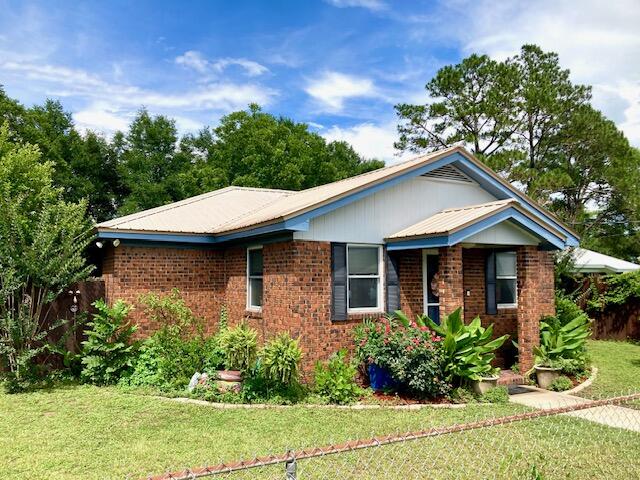 CUTE AS A BUTTON -- Great home is lovingly updated & maintained, but this growing family needs more room and they say SELL! The 3BR 2BA home packs a big punch in a very neat package. All brick, a metal roof & fenced yard allow low maintenance & privacy, while the location in the heart of town is so convenient. Living area & open kitchen with stainless appliances flows into a dining area & two bonus rooms for use as an office, den, hobby room, or home-school classroom. Laminate floors & Pella windows. Plumbing & wiring updated. HVAC new in 2014. Back yard very private with lots of storage under carport. New swing set is negotiable. Lite Industrial zoning makes a home business possible. Great potential as a family home, rental, or investment property, and just 30 minutes from the beach!