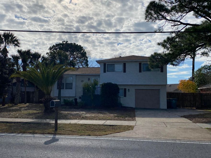 Beautifully tri-level 4-bedroom 2 bath home in the heart of Destin! As you walk in you will immediately feel at home in the open living room & kitchen concept. Upgraded kitchen includes stained raised panel cabinets, granite, and stainless-steel appliances,  includes door to a balcony that is great for entertaining! Living room nicely painted brick wood burning fireplace, designer lights and ceiling fans, all interior doors, luxury laminate flooring. Two guest bedrooms and guest bathroom are located on the upper level with the third guest bedroom/bonus room located on the lower level with door leading to single car garage. Large master suite includes sliding glass door to a large balcony overlooking the large fenced in backyard and inground pool.