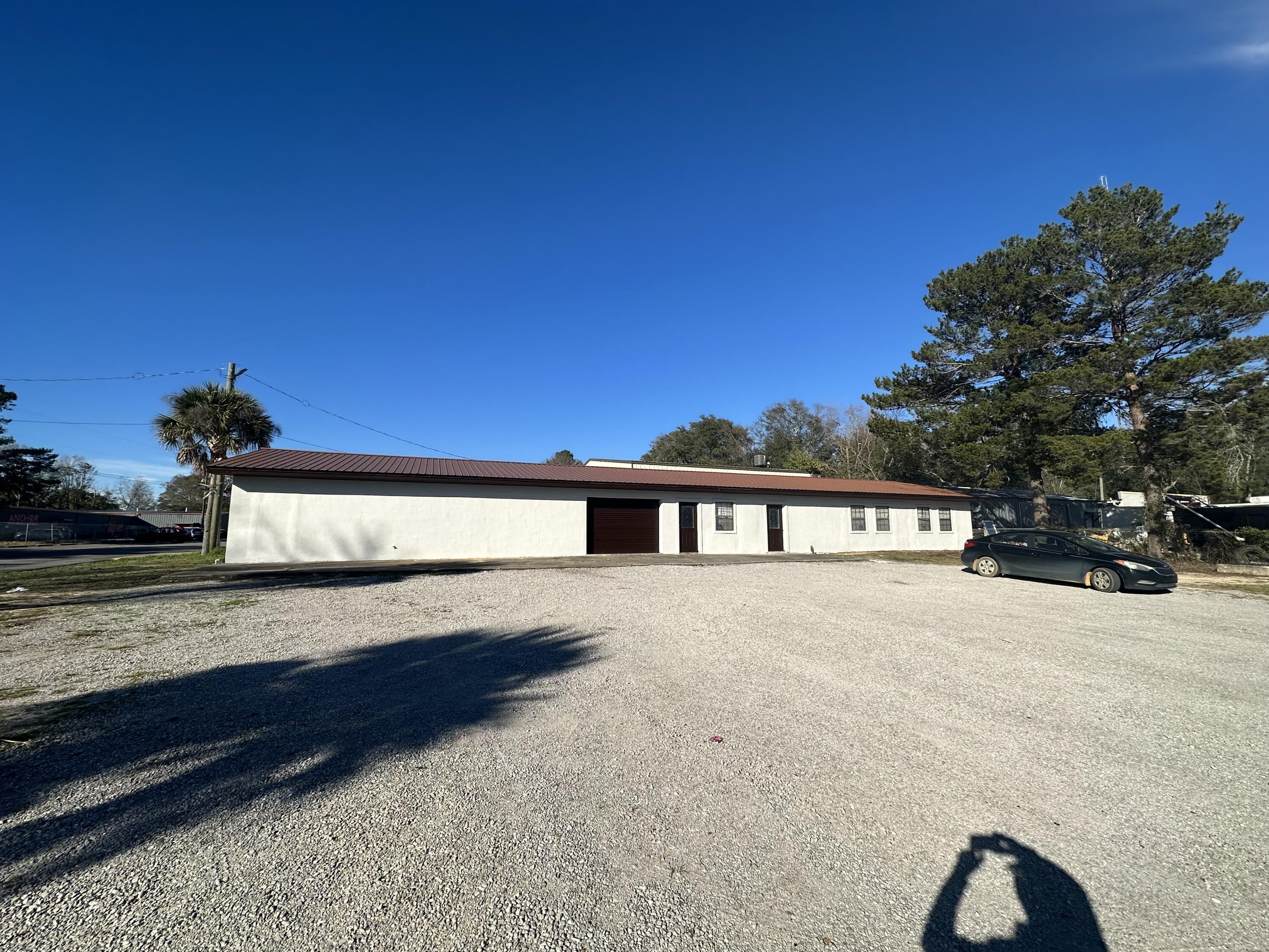 3,180sqft Large open, cinderblock building with stucco facade and metal roof. The building has only one interior cinderblock wall in the center that also has a large opening for a combined space. The building could easily be divided into two or more units, and there are four garage door openings in the cinderblock that could be opened back up as garage doors if desired. This building is a blank slate in a very convenient, central location that could be finished out into office space, used for warehouse, flex space, multi-tenant or other. Roll up door is 7' tall x10' wide