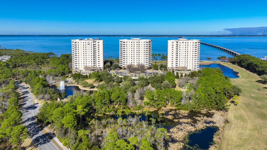 Located within Kelly Plantation, this condominium is in the east building of One Water Place. Views from this 10th floor condo are breathtaking, with panoramic views of Choctawhatchee Bay, the Kelly Plantation Golf Course, and the Mid-bay Bridge. The floor plan is the Darlington, characterized by its three terraces, spacious inside rooms, and three walls of windows in the master suite. The focal point of the residence is the beautiful living space with a gas fireplace and beautiful views of the Bay. Step out onto the spacious terrace and enjoy the views or prepare a dinner and entertain. The gourmet kitchen has upgraded appliances, granite counters, a breakfast bar and nook, center island, and custom integrated refrigerator. The dining room sits adjacent to the kitchen and features