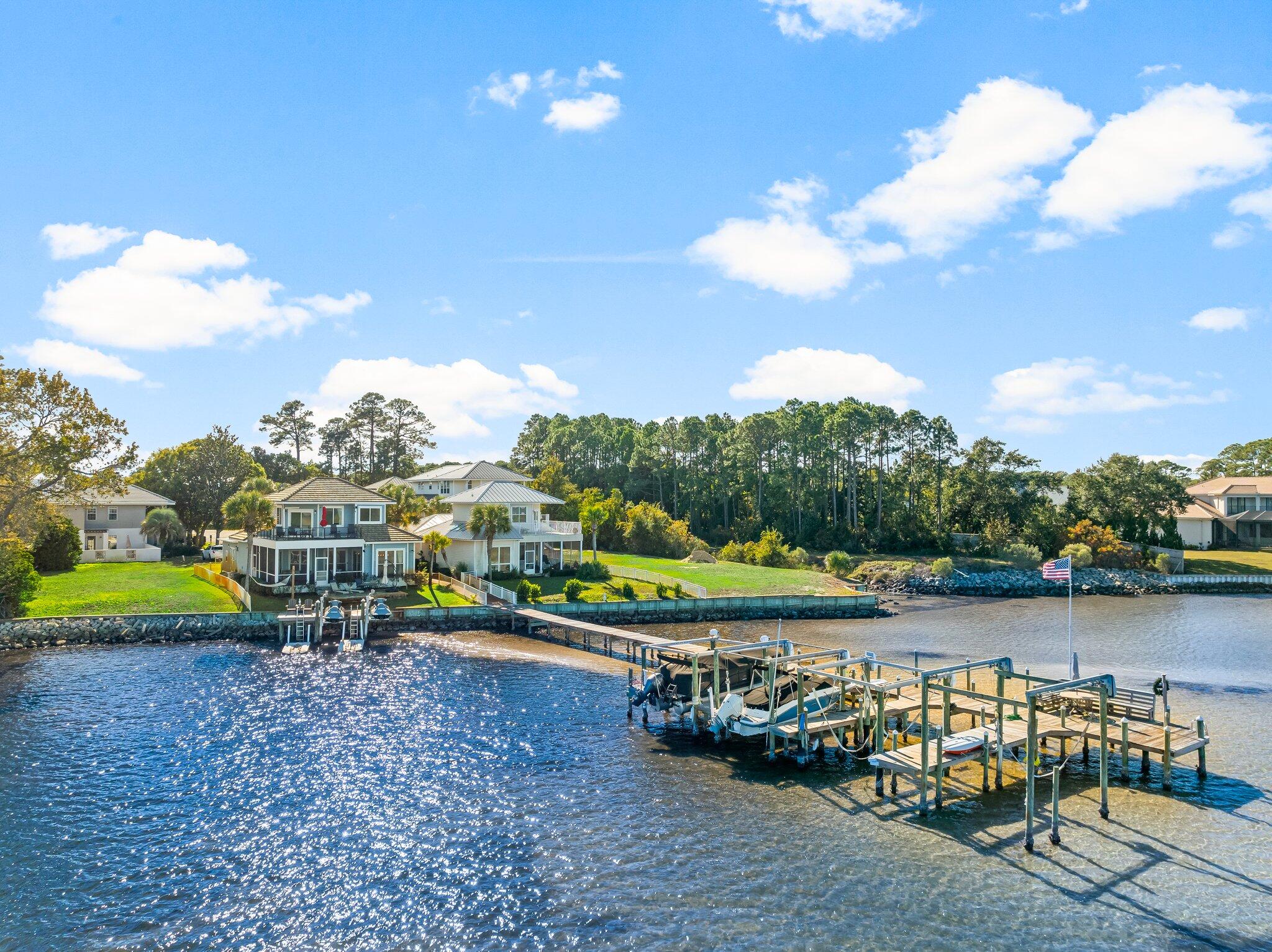 Discover your dream home with stunning waterfront vistas! Situated in the sought-after Bayshores Gardens community on the bayside of Miramar Beach, this open-concept residence invites you in with magnificent views and an abundance of natural light. This beautifully updated property boasts 3 bedrooms and 3 bathrooms, all within 2 miles of beach access, shopping, and a diverse array of dining options. The contemporary kitchen is a culinary enthusiast's paradise, featuring ample counter space ideal for entertaining friends and family. Expansive windows showcase breathtaking water views, allowing you to enjoy the scenery while dining at the breakfast bar or in the elegant dining area. Step outside to the newly constructed decking of the screened-in porch and unwind. Take in the tranquil water views! The layout includes two guest bedrooms conveniently located on the first floor, while the master suite, complete with an en-suite bathroom, is situated on the second floor, offering uninterrupted views of the bay. Experience spectacular sunsets right from your backyard, which features a charming brick-paver deck just a few steps from your private dock. Whether you're ready to launch your jet skis or boat, the exclusive HOA dock provides a designated slip and a boat lift that conveys. A quick ride across the water brings you to the renowned Crab Island, a favorite destination for locals.

This property also includes a one-car garage, currently home to a striking 2022 red Corvette 3LT that is available for purchase. The multiple outdoor decks and screened-in porch come fully furnished with umbrellas and seating, ensuring you can effortlessly enjoy the beautiful surroundings. Seize this remarkable opportunity to own a distinctive home with unparalleled bay views! Sold fully furnished with some personal item exceptions, additional options for purchase include two top-of-the-line 2022 Yamaha FX SVHO jet skis and a fully equipped 21-foot Sea Ray boat. This property truly offers an extraordinary lifestyle! 