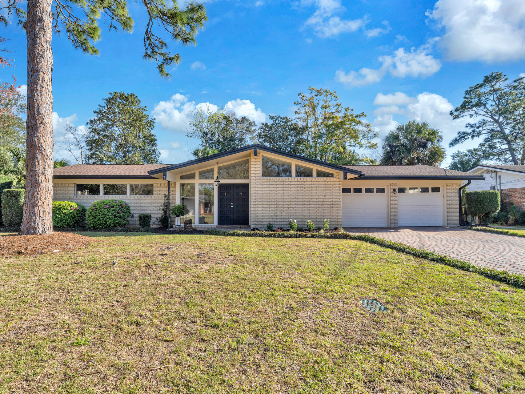 Gorgeous 3 bedroom 2 bath home with 2172 sq ft and .33 acres located in the beautiful Kenwood Neighborhood in Fort Walton Beach, FL. No HOA or flood insurance required! This home features a gunite pool (resurfaced 2016), paver driveway (2018), 30 year dimensional shingled roof (2017), newer windows and exterior doors (2016-2017), and copper wiring! A couple of blocks from the home are public pickleball and tennis courts, the Fort Walton Beach Golf Course, and a playground! This neighborhood is centrally located in Fort Walton Beach and is close to restaurants, the base, and the beach!! Enter the home through the double front doors into a foyer that opens to the dining room, kitchen and living room! The foyer features custom pendant lighting and large, picturesque windows! The first living room features a built in bookcase and double French doors to an open patio. This smaller patio is off the living room space and allows for additional outdoor entertaining! The French Doors to the patio have built in blinds. The kitchen features an island that seats 4, granite countertops, a French door refrigerator, build in microwave, dishwasher, electric cook top, and wall oven. There is a built in wine and China cabinet which is perfect for extra storage. The home has an open floor plan with the kitchen opening to a 2nd living room space, sitting room, fireplace and extra space for a home office. There are so many possibilities with this floor plan! The primary bedroom is large and has an ensuite bathroom! There are views of the gorgeous backyard and pool from the primary bedroom. The ensuite bathroom has a walk in, tiled shower. There are two additional guest bedrooms and a guest bathroom. The guest bathroom has a tiled tub and shower surround, pedestal sink with a tiled wall and backsplash. The backyard features a large, gunite pool, extra pool decking, a side yard with a storage shed, and a privacy fence! There are also rain gutters on the home and a two car garage! There is plenty of parking for an RV or boat and trailer. This home is located in Kenwood Neighborhood and just around the corner are public pickleball and tennis courts and a golf course. The military base and beaches are not far from this home! This home is mid century modern with contemporary upgrades. Buyer to verify all dimensions and information.