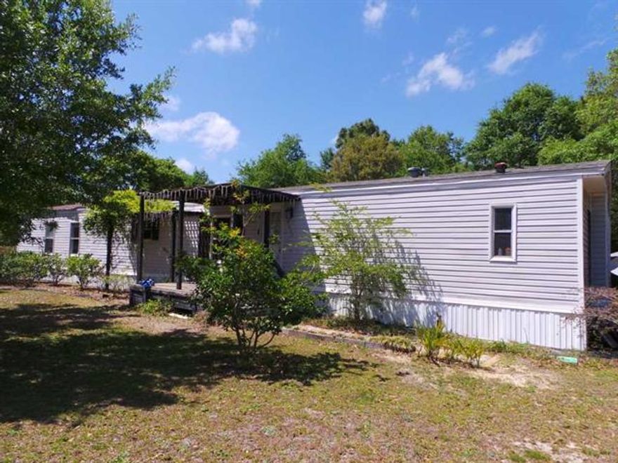 County living in this three bedroom, two full bath home. Convenient to beaches, shopping & dining via Hwy 98. Easy access to I-10 via Hwy 87. Home offers a covered front deck, screened porch in the rear & workshop. Interior features vaulted ceilings, ceiling fans in all rooms, huge eat in kitchen & master suite with a garden tub & double vanity in the bath. Tons of potential here!