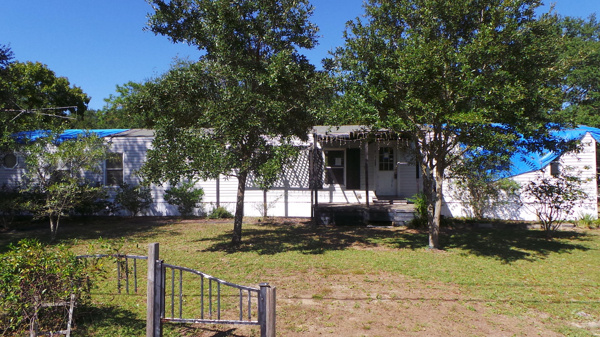 Country living in this 3 bedroom, 2 full bath home. Convenient to beaches, shopping and dining via Hwy 98. Easy access to I-10 via Hwy 87. Home offers a covered front deck, screened porch in the rear and workshop. Interior features vaulted ceilings, ceiling fans in all rooms, huge eat-in kitchen & master suite with a garden tub and double vanity in the bath. Tons of potential here!