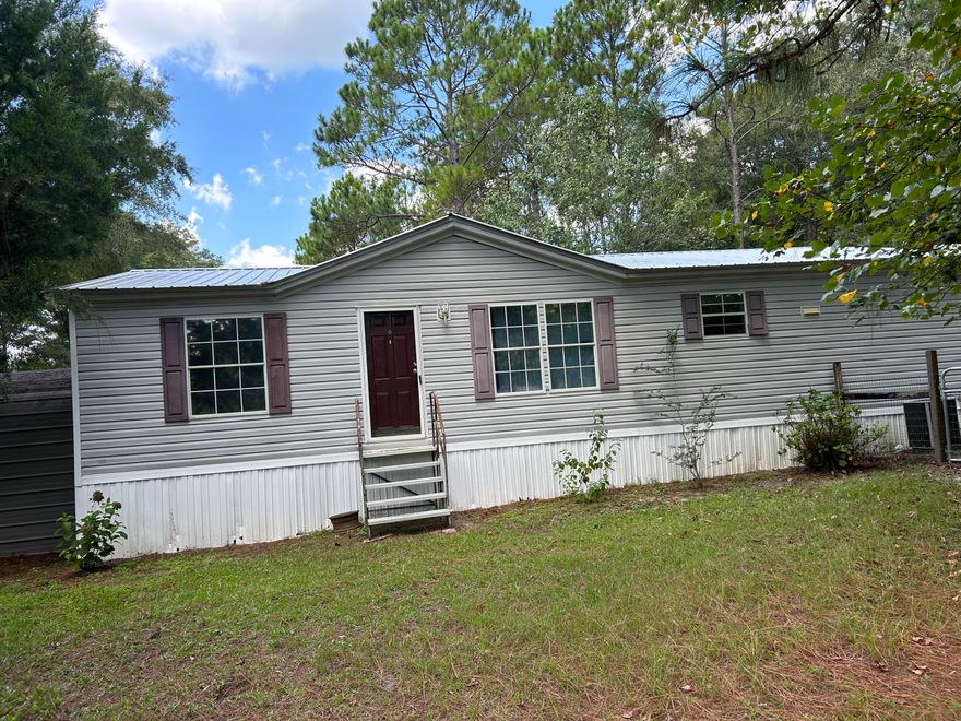 Price improvement on home and 4.5 acres in country setting. Motivated seller.  If you want to be away from the hustle and bustle in the country with some elbow room, this one is for you.  One hour drive to beautiful beaches of south Walton and Panama City Beach.  Home has newer metal roof put on in September, 2022.  Half of the land has been cleared. Wooded area on back portion. Two car carport with concrete slab. Metal barn for storage. There is also a second 2 car carport.  Fenced in area for pets in front yard. Hardwood floors throughout, large living room with wood burning fireplace and cathedral ceilings, master bath with garden tub, shower, and double vanity, lots of closet space. Fronts paved road. No HOA and no restrictions known. Call us today.