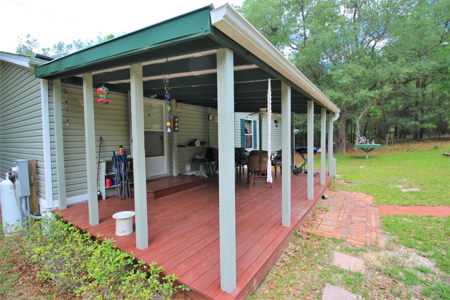 Country life! This very well maintained home greats you with a 19' front porch, landscaped front yard, and garden. Inside you'll find an open floor plan and 2 good sized bedrooms, each with a full bath. Furnishings can convey! A covered deck overlooks the natural back yard with plenty of trees and room to roam. Complete with a large custom built to match workshop with power and metal roof.