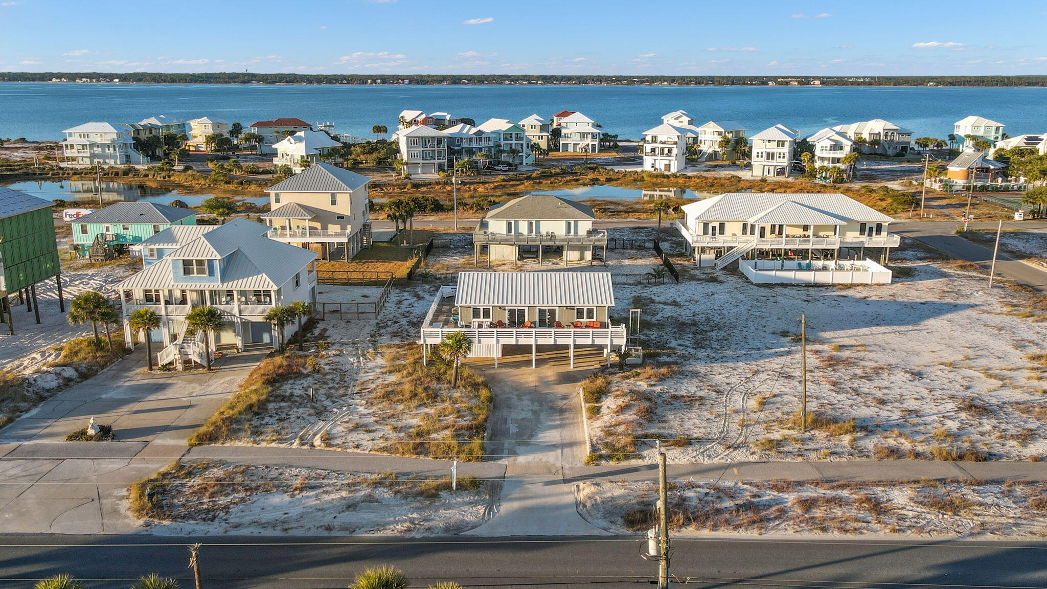 Offering a lifestyle that only Navarre Beach can deliver, this lovely Beach Cottage is located across the street from the Gulf so you can enjoy the sound of waves gently crashing on shore, warm Gulf breezes, both Gulf and Sound/Intracoastal water views, a gathering place for beach lovers for making a lifetime of memories - all from this beautifully renovated home with a expansive deck.  Featuring 4 bedrooms, 2 baths, a sun room, a 3/4 wrap deck that visually and physically expands the dedicated living space into outdoor living space with 2 sets of stairs, a downstairs workshop & office (not included in square footage) an outdoor shower, covered parking for cars and toys, a cargo lift elevator for conveniently moving items to the upstairs area, and a short walk to public beach access...