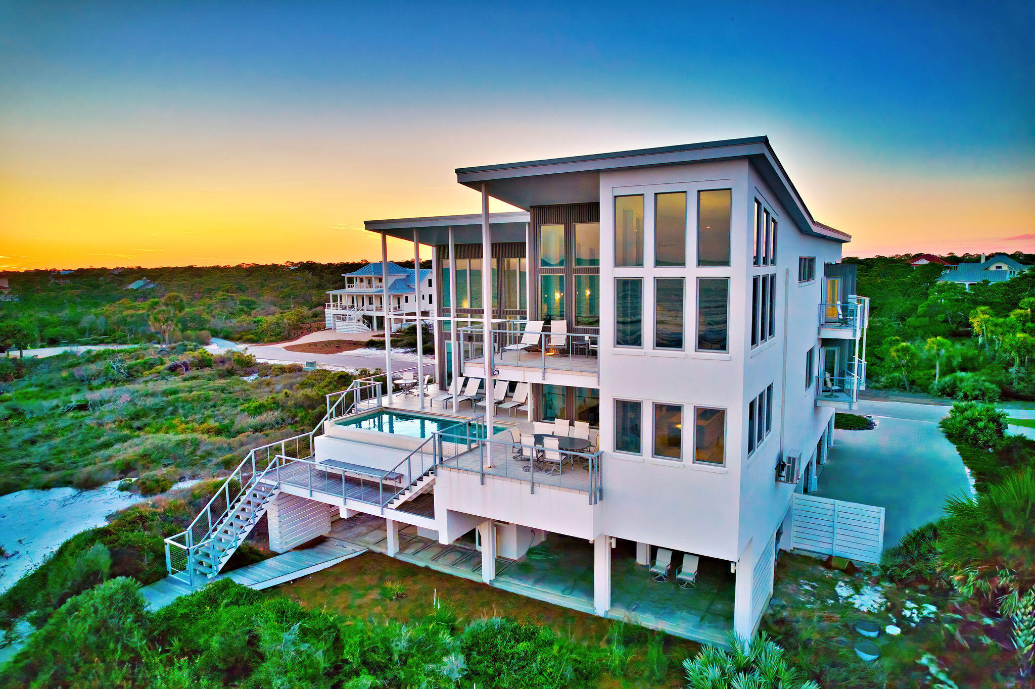 Welcome to Sugar Sands Sanctuary, an exquisite Gulf front legacy home nestled in the gated community of The Plantation on St. George Island. Designed by renowned architect Carey McWhorter, this contemporary masterpiece spans over 5,000 square feet and boasts 100 feet of stunning beachfront on the Gulf of Mexico.From the moment you arrive, you are greeted by covered concrete parking and a spacious, enclosed foyer with an elevator for convenience. The first floor features an open living/dining/kitchen area with soaring two-story ceilings and walls of glass that provide breathtaking Gulf views. The elegant and serene decor, combined with comfortable seating, a flat-screen TV with a home theater system, and direct deck access, creates the perfect atmosphere for relaxing and entertaining.
The chef's kitchen is a culinary dream, equipped with designer stainless appliances, double ovens, two refrigerators/freezers, quartz counters, custom cabinetry, a large pantry, and a separate breakfast bar. Mealtime is a delight with ample seating at the large dining table and breakfast table, both offering stunning views of the Gulf as a backdrop for unforgettable memories.
Step outside to the expansive deck space, where you will find an amazing infinity pool elevated above the dunes and overlooking the Gulf of Mexico. The outdoor living area is beautifully furnished with lounger chairs and tables, providing the perfect setting for al fresco dining and enjoying the Gulf breezes.
Sleeping accommodations on the first floor include the NE king primary bedroom with a private balcony and flat-screen TV, the East king primary bedroom with a private balcony and flat-screen TV, and a bunk bedroom with two bunk beds (full/full and twin/twin), a flat-screen TV, and an attached full bathroom. The second floor features an interior balcony overlooking the living area, a desk/workspace ideal for remote work or study, and additional luxurious sleeping quarters.
The SE king primary bedroom on the second floor offers an enormous walk-in shower, soaking tub, private deck access, flat-screen TV, stunning Gulf views, and a private sitting area. Additional sleeping accommodations include the NE king primary bedroom with a private balcony and flat-screen TV, and the East king primary bedroom with a private balcony. Both the first and second floors have laundry areas with washers and dryers, and an additional full bathroom on the first floor for added convenience.
This turnkey home is beautifully furnished and ready for you to move in. With concrete and steel construction, it is built to withstand hurricanes and offers generous storage inside and out. The expansive outdoor spaces and gorgeous views from every room make this family home perfect for beach living and entertaining.
Sugar Sands Sanctuary is not just a home; it's a lifestyle. Enjoy exclusive community amenities, including tennis courts, a fitness center, nature trails, bicycle paths, and access to Nick's Hole Cove and Apalachicola Bay. Located near island shops, restaurants, nightlife, and the St. George Lighthouse Museum, this secluded and serene sanctuary offers the best of the Forgotten Coast within easy reach.
Experience luxury, comfort, and timeless memories at Sugar Sands Sanctuary. This is your opportunity to own a piece of paradise on St. George Island
