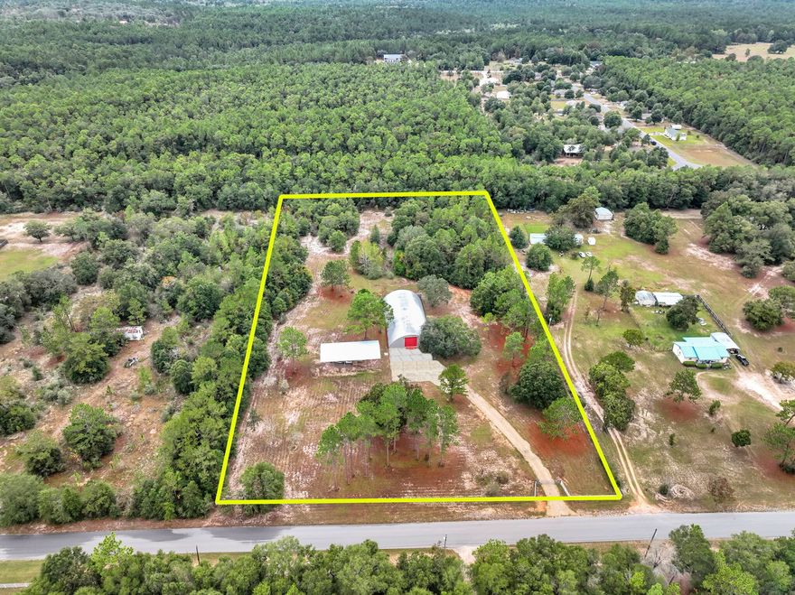 Located just outside the thriving Crestview corridor, this exceptional 4.47 acre property offers a rare blend of commercial flexibility and expansive outdoor space. Upon entering through newly installed electronic gates, you'll immediately appreciate the scale of what awaits: a 5,000 square foot Quonset hut set atop a 15 inch concrete slab, complete with a loading dock, full utility access, and a rooftop sprinkler system designed to moderate interior temperatures. Alongside the main structure sits a new pole barn sized for a 45 foot RV, and the site is further enhanced by two municipal water meters, a deep water well, two like new septic systems, and three full RV hookups including 30 AMP and 50 AMP service.