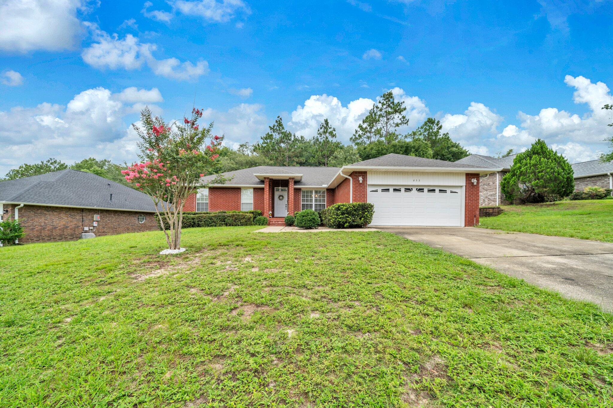 NEW ROOF with ACCEPTABLE OFFER! Nestled in the heart of Crestview's Favorite - Fox Valley a community with playgrounds, landscaped medians, and sidewalks. 653 Territory Lane is beautifully proportioned and thoughtfully designed home. Built in 2006, this 1913 sq. ft., brick‑accented, one‑story home sits on a partially fenced 0.25‑acre lot that backs to lovely trees for a quiet setting.The split‑bedroom design offers privacy and flow. The large master suite includes double vanities, a walk‑in shower, and separate tub. A center island in the kitchen makes meal prep a joy. A separate dining room includes a coffee / wet bar--ideal for elegant dinners or casual cocktails. The open living area's soaring ceiling enhances the sense of space and light. Interiors are accented with vaulted ceilings, tile and vinyl flooring throughout. Step onto the painted deck that overlooks a fully fenced yard, ideal for play, pets, and entertaining. Located just minutes from Eglin AFB and 7th Special Forces Group.
Current Roof 2006 - HVAC 2006 - HWH 2025.
Listing agent has resourced lot information from the County Property Appraiser's website. While the listing agent believes that the acquired information is accurate and true, the buyer and/or buyer's agent should verify all details related to this property prior to purchase.