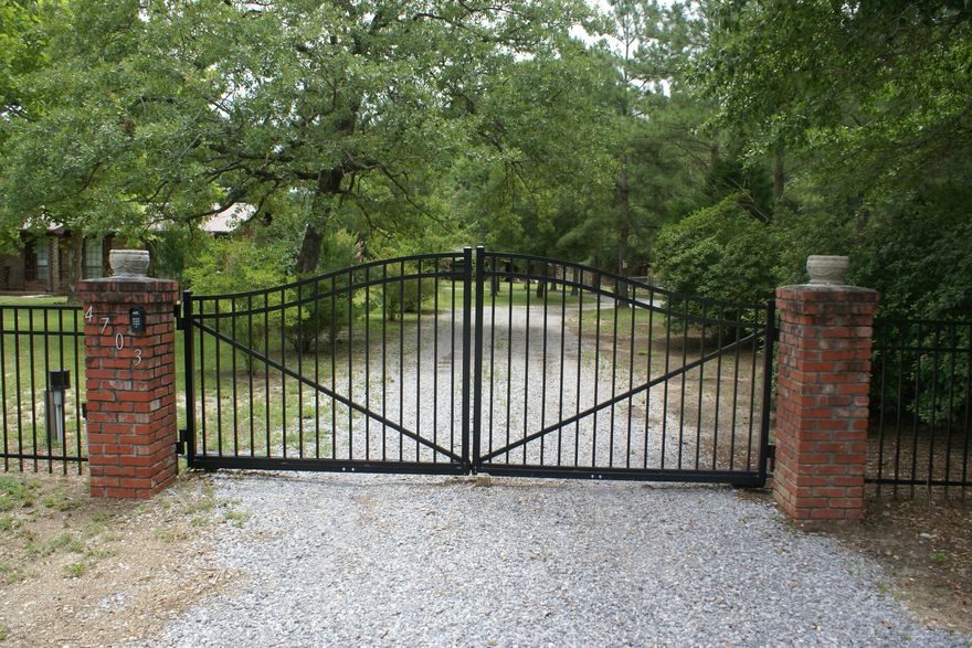 As you approach the remote controlled 6 ft. METAL GATES you will know you have arrived at somewhere special! The black metal 4' fencing flanks the entire length of the front yard and transitions to a 6' wooden privacy fence encircling the property's 2.3 acres. The front porch is also flanked with a shorter black metal fence. There is updated underground electricity & new panels with 200 AMP service for both home and the 2000 sq ft RED STEEL BUILDING with 3 automatic GARAGE BAYS along the front and a side door for entrance. Lighting is provided by the 16 4' florescent lights in the garage ceiling. Home has METAL ROOF and brand new A/C. All exterior/interior doors were replaced 2010 and new windows were installed in the original screened porch creating the FL room. 15 minutes to Duke F