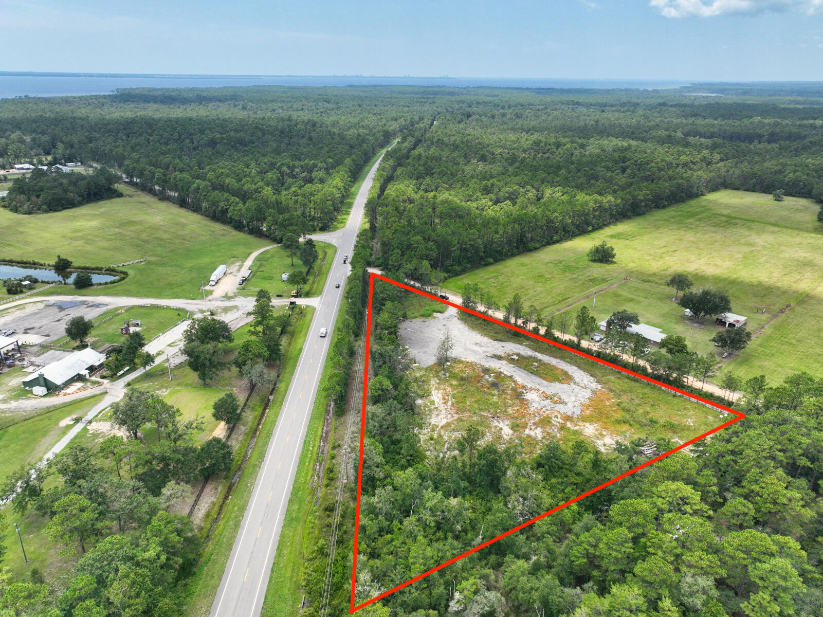 Build your dream home with plenty of room to breathe! Country living with plenty of privacy. Residential Lot just shy of 5 acres has been partially cleared. This triangular lot with 912' facing Highway 20 and 646' facing King Road has an access with a gate to the cleared area on King Road. A buffer of trees along Highway 20 provides privacy and a privacy fence has been installed on either side of the gate. Gulf of Mexico beaches within 30 minutes by way of the Highway 331 Bridge.