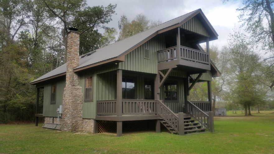 Located on Pea River near Samson, AL this gorgeous secluded hunter's dream, farm or family home on this 200 acre tract with a 2280' s.f. cabin freshly painted poplar wood sided secluded from the main highway.  Home comes fully furnished.  Has  central air and heat, porches, balconies, 2 wells, even a 'hand pitcher pump', pole barn that served as a saw mill, with small efficiency living quarters in the back. The 200 acres (appx. half is cleared and leased for peanut planting, other half is wooded land that fronts on Pea River.   Property is partially fenced and cross fenced, 2 ponds, 2 hunting houses, electricity on other sites of the property. Complete with an out door bathroom (with commode & running water). All kind of wildlife stroll this property.   This is a dream property!