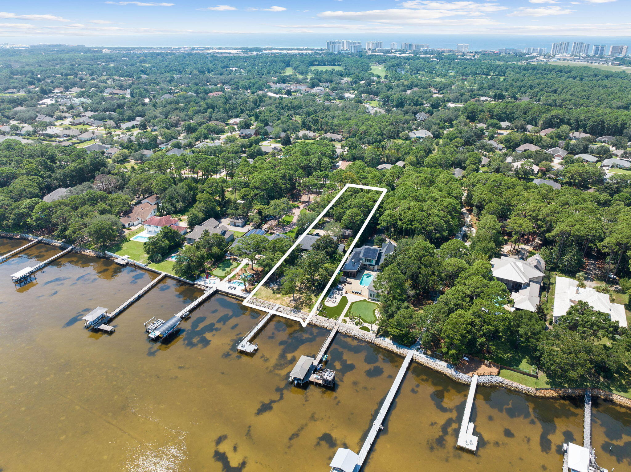 This charming two-story, 4-bedroom, 2.5-bathroom residence in Destin, FL, offers a prime bay front location on a spacious 1.13-acre lot. With 2,499 square feet of living space, this home provides a comfortable and inviting environment for a relaxed coastal lifestyle.Step onto the covered porch and take in the panoramic views of the bay, offering a perfect spot for outdoor relaxation and gatherings. The property also features a new private dock with flow-through decking, perfect for boating and water activities. A recently built seawall and riprap add durability and protection to the bay front.Inside, the open-concept layout includes a modern kitchen with updated appliances and ample storage. Large windows in the living area showcase scenic bay views and natural light.