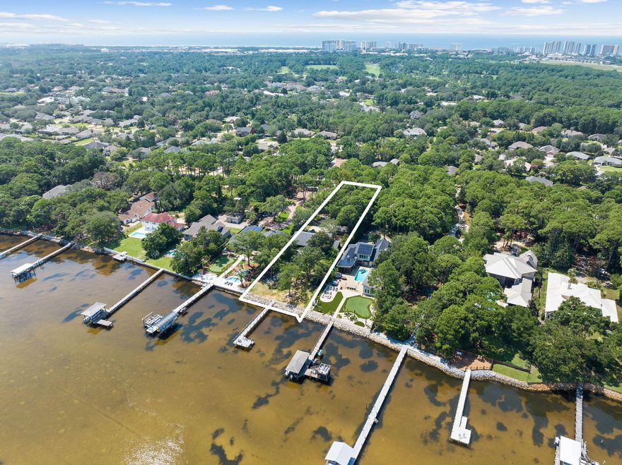 This charming two-story, 4-bedroom, 2.5-bathroom residence in Destin, FL, offers a prime bay front location on a spacious 1.13-acre lot. With 2,499 square feet of living space, this home provides a comfortable and inviting environment for a relaxed coastal lifestyle.Step onto the covered porch and take in the panoramic views of the bay, offering a perfect spot for outdoor relaxation and gatherings. The property also features a new private dock with flow-through decking, perfect for boating and water activities. A recently built seawall and riprap add durability and protection to the bay front.Inside, the open-concept layout includes a modern kitchen with updated appliances and ample storage. Large windows in the living area showcase scenic bay views and natural light.