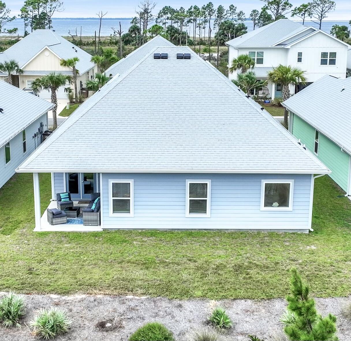 Situated perfectly along Sea Grove Way, this home offers the best of coastal living, with two boardwalks providing beach access at each end of the street and the community pool at one end. Inside, you'll be greeted by elegant granite countertops, luxury vinyl plank flooring, and soaring 9-foot ceilings, creating a bright and welcoming atmosphere. A standout feature is the fully equipped mother-in-law suite, complete with a private entrance, kitchen, bedroom, bathroom, laundry, and separate heating and cooling--perfect for guests, family, or rental opportunities. This home is turnkey and ready for immediate occupancy, making it an ideal choice for residents and investors alike. In addition, a serene pond awaits at the rear of the property, offering a peaceful retreat right in your backyard. Windmark Beach is a vibrant, golf cart-friendly community featuring a scenic 3-mile trail, perfect for golf carts, biking, walking, or running. Enjoy access to two resort-style pools, a variety of dining options including a bar, restaurants, and a pizza place. The community also offers a gym, beach gear rentals, and a dog park, providing everything you need for a relaxing coastal lifestyle.