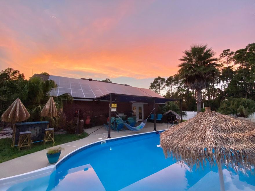 OPEN HOUSE Sat 11/19 & Sun 11/20 1:00 - 3:00. This is Florida living at its' very BEST! Fabulous Navarre POOL home perfect as a Vacation Rental or Primary home!
A stunning Tropical Oasis awaits in the fully fenced, big back yard and is so very perfect for entertaining and outside *FUN* with a large Saltwater Pool featuring a Swim Shelf and Bar; a Volleyball Court, large Workshop, a Tiki Bar and a large Pole Barn for your RV, Boat or Toys! This pretty home with great curb appeal, Palms and Tropical Plants, had a brand New Roof installed in October and features top of the line Tier 1, 2020 Solar panels that cover the entire electric bill and which will be paid off by the seller at closing. As you step through the Front Door, you will enter into the spacious and bright living area with its' high Vaulted Ceilings, Spanish Lace walls and beautiful tiled floors. The home features a split floor plan, a nice sized Master Bedroom and Bath with separate Garden Tub and Shower, plus his 'n hers Walk in Closets. The Kitchen has all Stainless Appliances, a Pantry and Breakfast bar, with French Doors leading out to the covered Patio and Pool from the adjacent dining area.  Other exciting updates and features include: a 2020 Solar/Elec water heater and 2020 2.5 ton HVAC system, an RV Pad with 50 AMP hook up AND septic/water connectors plus a level 2 EV charger and an Auxiliary Power switch for a portable Gas/Propane Generator. The home even has a Culligan whole home water softener System with Reverse Osmosis.  The Washer/Dryer, Smart Thermostat and Security Cameras all convey too! Great Location! Less than 10 minutes from Beautiful Navarre Beach with shopping and top-rated Navarre schools very close by, plus NO HOA!!
BACK ON MARKET DUE TO BUYERS FINANCING FAILING AT THE 11TH HOUR! Their loss could be your gain!!