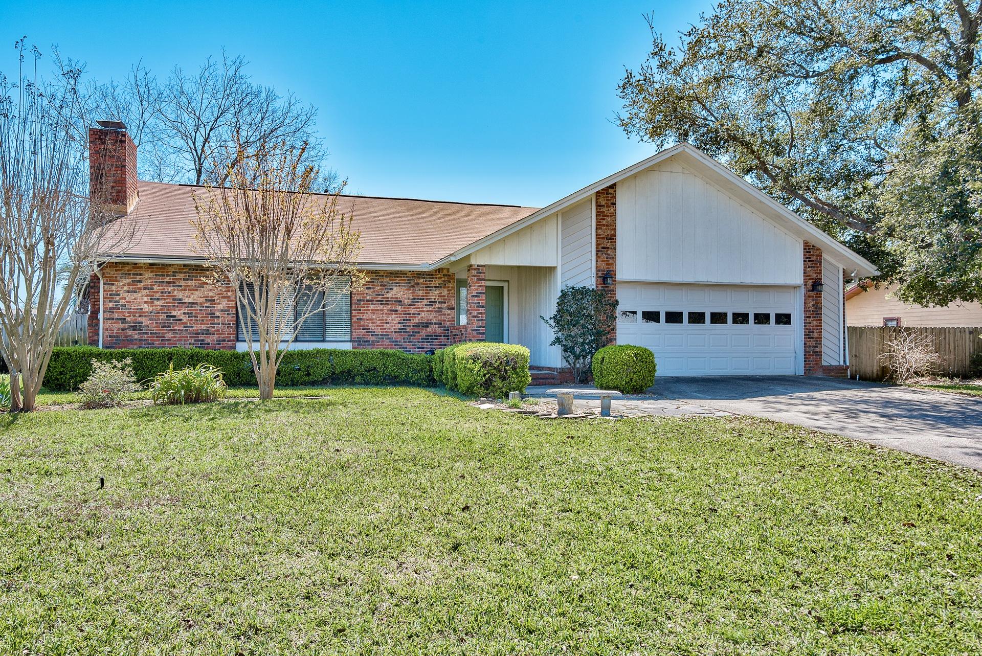 Look no further for your piece of paradise in the heart of Destin! This 4-bedroom, 3-bath charming all brick home sits on a 0.25 acre lot with a large fenced-in backyard with gorgeous landscaping, a gazebo, and plenty of room to add a full size pool. The interior features beautiful hardwood floors throughout the living & dining area along with vaulted ceilings for a spacious feel. The open living area has a traditional wood burning fireplace for ambiance. The kitchen was newly remodeled with beautiful granite countertops & island, contemporary white cabinets, custom backsplash and stainless steel appliances. Enjoy the large tiled Florida room and patio and take in the serene environment. There are two master bedrooms which is a rare bonus and two guest bedrooms, all featuring carpet.