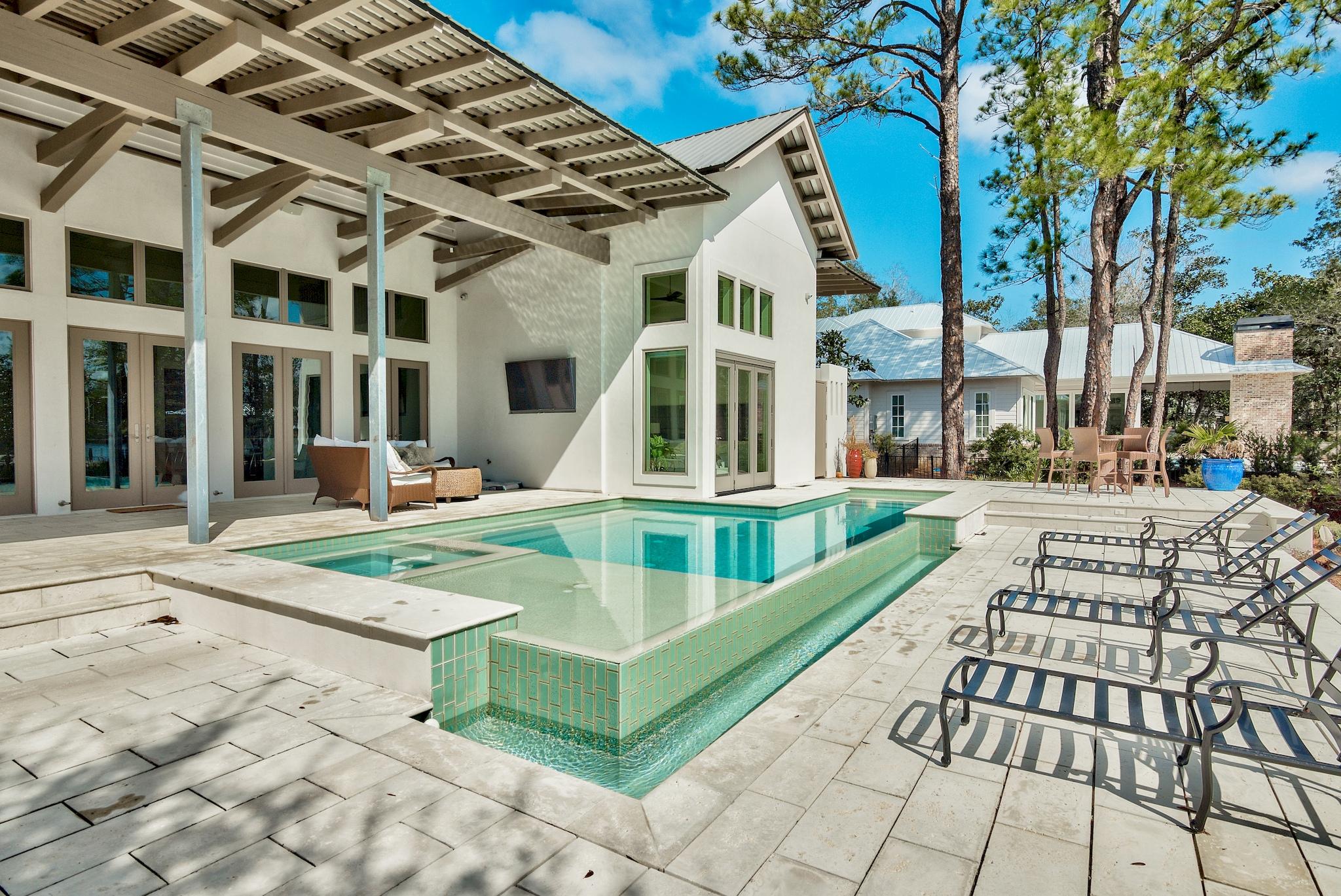430 Botany Boulevard is located in the gated community of Botany Bayou ideally situated between Miramar Beach & Scenic 30a. Natural beauty abounds on the wooded lot of mossy oaks, mature magnolias and shrubby palmettos. Boat dock and lift along with additional jet-ski lift enable boaters to take full advantage of life on the water from Day 1.The Modern-inspired design of this contemporary beauty are realized before even stepping foot inside. White concrete with tan accents and clean lines create eye-catching curb appeal. Upon entering the home, you become immersed with the idea of bringing the beauty of outdoors inside. The 24 foot cathedral ceiling allows for a wall of french doors with oversized transoms to brighten the home with natural light