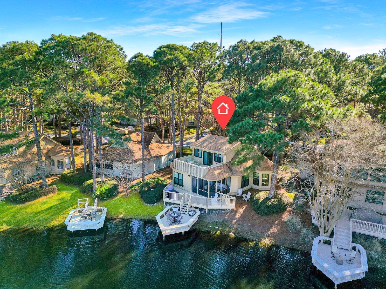 Lake front living in the heart of the Fairways of Sandestin! This 3BR/3BA coastal cottage delivers on everything you could desire  for the perfect home or a vacation rental. A private dock on the lake serves as the ideal spot to watch the sun rise or set in the distance after a long day at the beach.  An elevated terrace gives life to an outdoor kitchen, to grill up dinner al fresco, overlooking the lake. A third outdoor area, fully screened, will swoon you into a leisurely nap or entice you to curl up with a good book with tall mature pines swaying above.Beautifully renovated, new kitchen appliances, quartz countertops, updated bathrooms, soft close cabinets, new exterior paint, and a new hot water heater add to this turn key two story cottage for easy living.