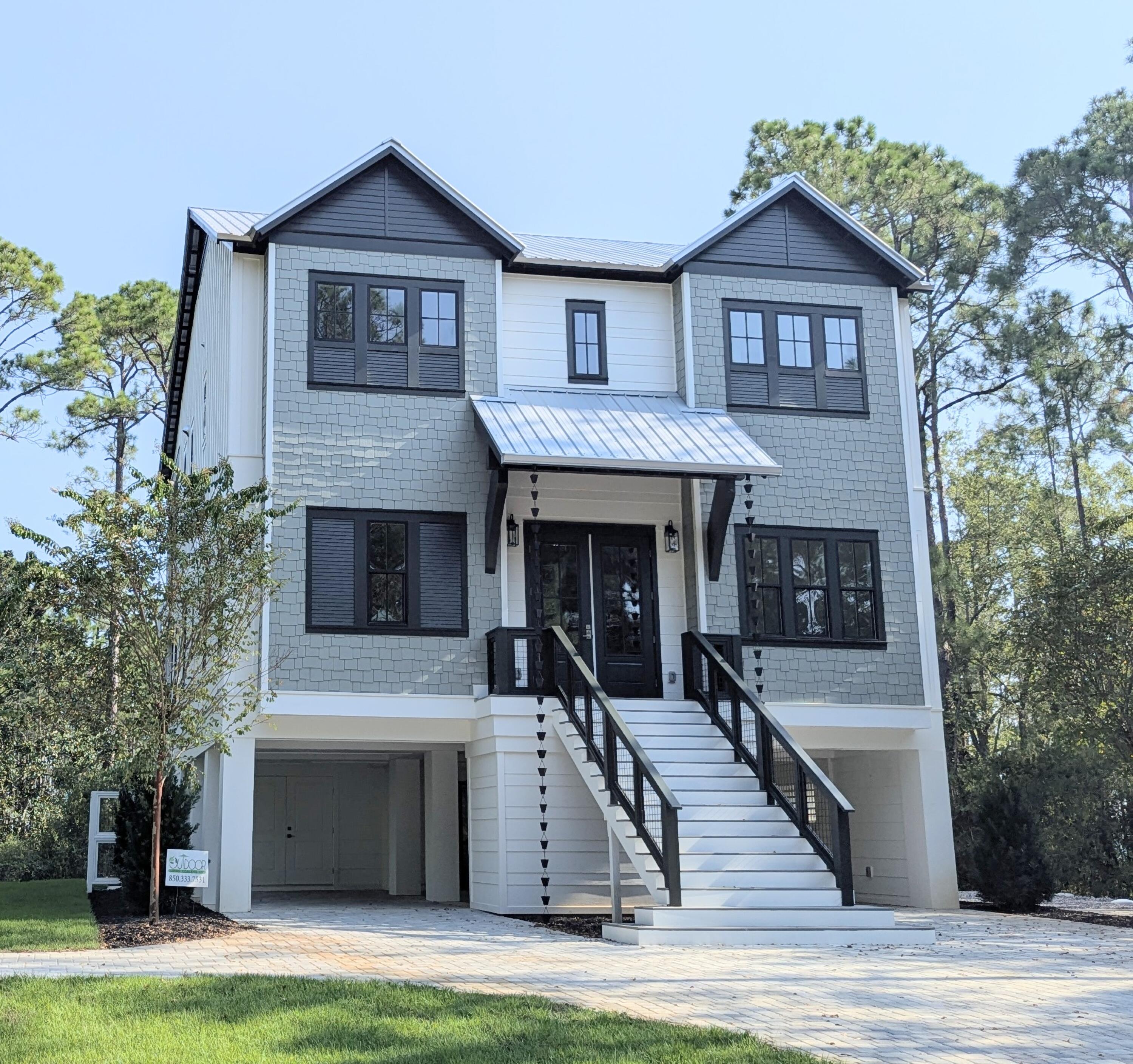 Amazing NEW CONSTRUCTION home tucked away on half an acre lot. This custom 5 bedroom,3 1/2 bath home would make for an excellent primary residence, second home or investment property. The bottom floor features a saltwater swimming pool and full-size kitchen with bar sitting area for entertainment finished with built-in Sonos speakers, covered parking, storage and half bath. First floor consists of a large primary suite with a private en suite bathroom featuring a wet bath, French door to oversized porch and two more bedrooms. The top floor features an open kitchen-living area designed for both elegance and functionality, custom cabinets, pristine quartz countertops, large island, sleek stainless-steel appliances, wet bar, pantry and three more bedrooms. The top and bottom levels feature expansive porches, offering a delightful space for relaxation and enjoyment. The kitchen/living area has a 12 ft Euro Glass Wall that opens to the porch bringing the outdoors in.