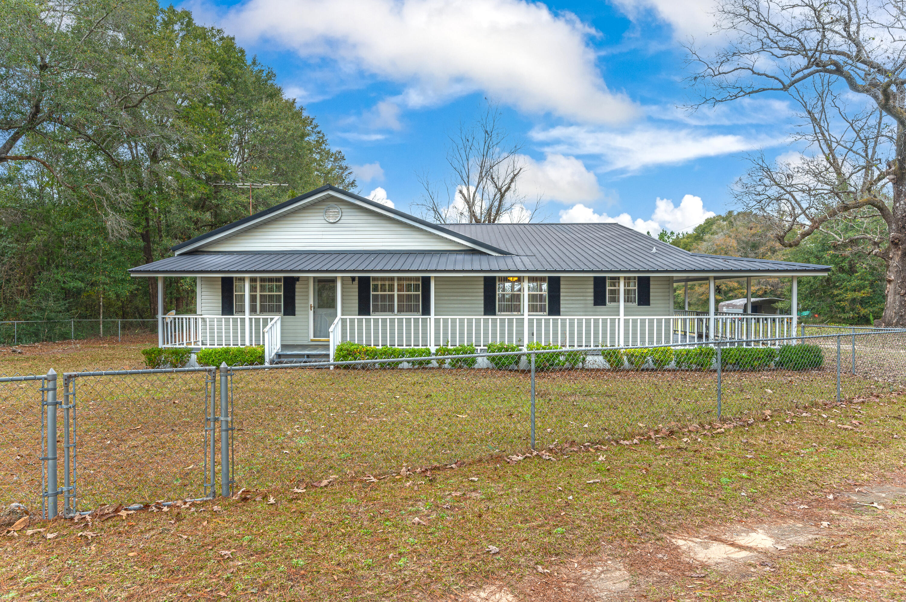 BACK ON THE MARKET!!!!! NO FAULT OF SELLER. This beautiful 3 bedroom/ 2 bath home with wrap around porch on 3.49 acres is ready for you to make it home. This home features real hardwood floors in the living room and tile throughout the kitchen/dining room area. Living room features a wood burning stove with rock accent wall. Home has a metal roof, newer HVAC system and septic tank. The oversized kitchen/dining room area is perfect for entertaining guest. The backyard is level and perfect for outdoor games. There is also a storage shed and a workshop for yard equipment and tools. Come enjoy this country living with the convenience to military bases, shopping, restaurants, interstate and of course the beautiful beaches.
