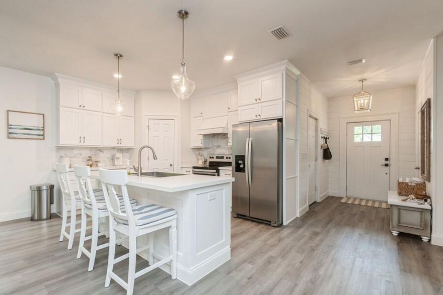 Beautifully maintained coastal home with an open, airy layout that exudes comfort and style. Everywhere you look, you'll find thoughtful custom finishes. Nine-foot ceilings and luxury vinyl plank flooring throughout enhance the spacious feel. The kitchen features quartz countertops, marble backsplash, vent hood, and custom cabinetry. A floor-to-ceiling built-in with electric fireplace adds warmth and charm. Just three miles from the ocean and one mile from the Bay's public boat launch. No HOA or monthly fees. Enjoy the freedom and elegance of beach living!