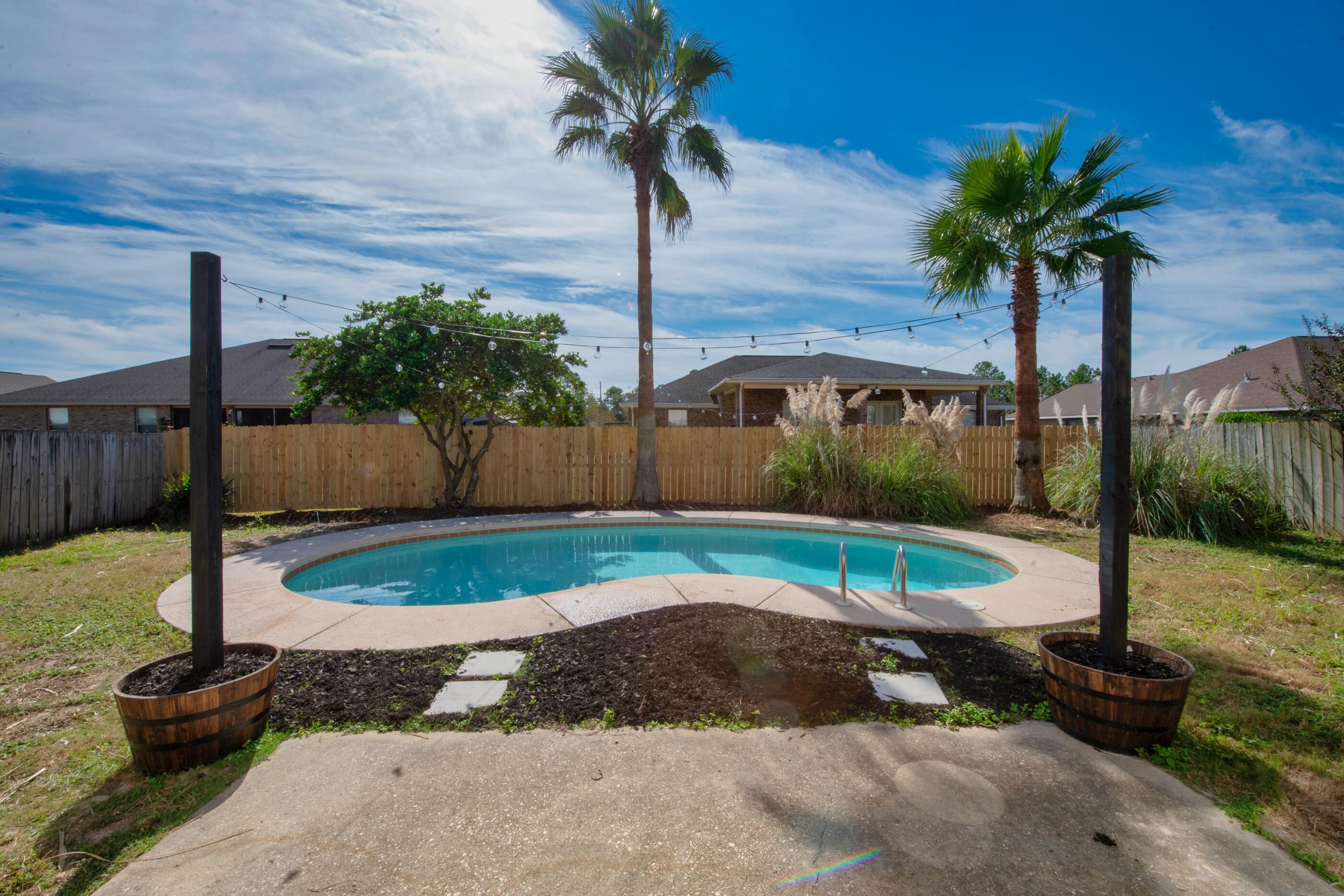 This home is truly one of a kind property. You're looking at 1 of 2 total private pool homes in Parker's Landing subdivision out of 86 homes. One of the most special homes on the market currently, with over $20k invested in renovations within the last 30 days. Totally renovated from the ground up, to include new floors, interior paint throughout, granite counters, stainless appliances, all new lighting and fixtures, and a custom shiplap coffee bar. A boho inspired renovation style provides views of the backyard paradise from almost every room. Beautiful bronze accent fixtures throughout both bathrooms and kitchen compliment subway tile backsplash. Not only is the backyard a paradise, but so is the neighborhood. You'll love the private lake, large fields for animals to run, pergolas scattered throughout, a gorgeous walking trail circumventing the subdivision, and a protective private swing gate monitored by code just to gain entry. This home was loved, and the unique design style was done to compliment the ownership experience. Private pool homes are rare in Navarre, combine that with a dreamy neighborhood close to beaches and bases, this home is truly one of a kind on the marketplace today. Book your private showing today.