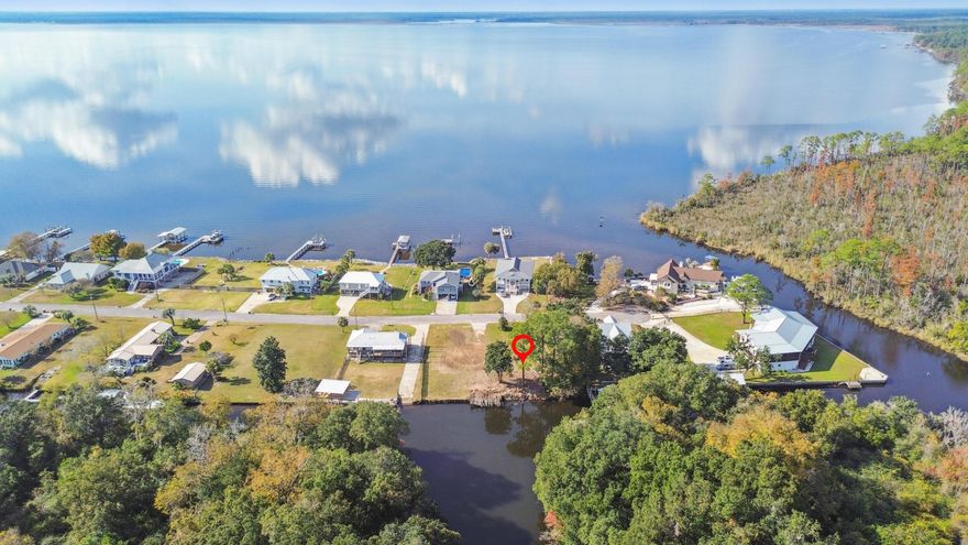 Waterfront lot on a deep‑water canal with direct access to Perdido Bay and the Gulf. Ideal site for a custom home or seasonal retreat. The canal easily accommodates a well‑sized cabin cruiser, offering quick, unobstructed trips to open water.Quiet setting with a sense of privacy, yet close to Orange Beach, Pensacola Beach, dining, and marinas. A rare opportunity to build in a location that blends calm, convenience, and long‑term value.