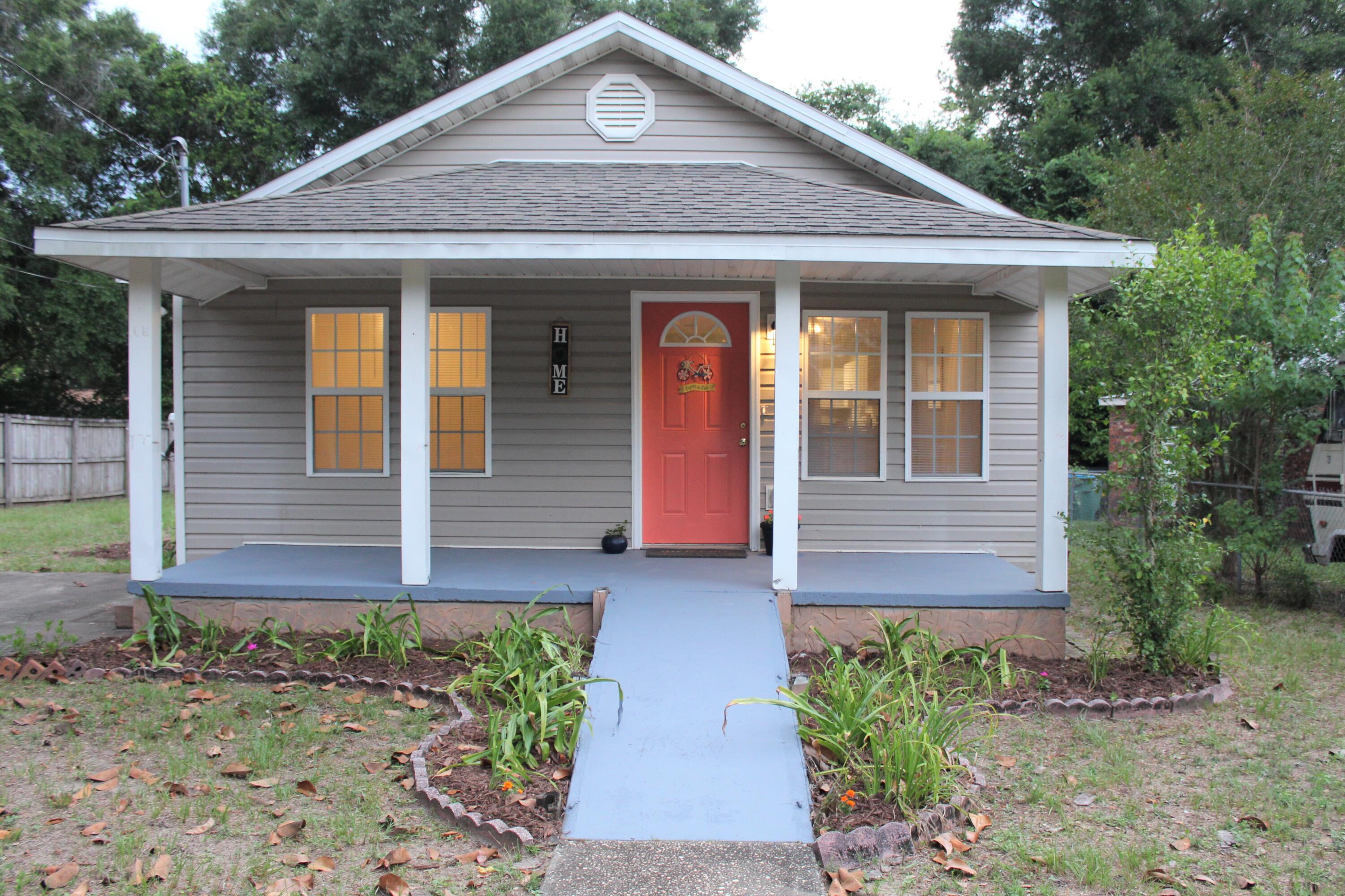 Check out this adorable 3 bedroom, 2 bath, Florida Cottage conveniently located just a few blocks from Hwy 90 and Hwy 85 in Crestview. You're sure to notice the freshly painted coral front door. Enjoy morning coffee on your large, covered front porch (which offers a ramp for increased accessibility), relax in the back yard, or grill out on the deck--with easy access to the kitchen from the back door. The kitchen has bright white cabinets with decorative shelves for displaying your favorite things, and lots of counter space! The breakfast bar opens to the dining area and living room; the open concept is great for entertaining! The space is light and bright with neutral light gray paint and lots of windows!