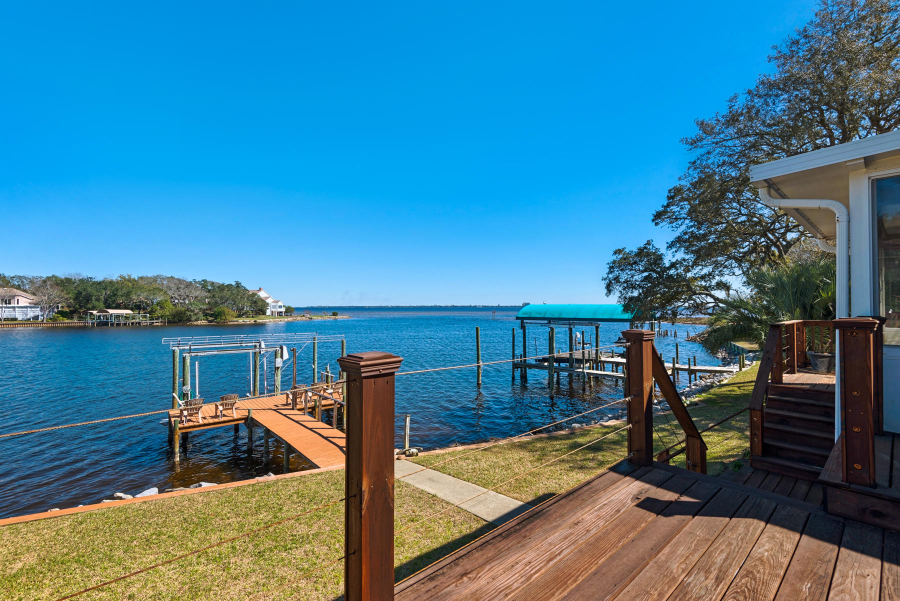 Outstanding, contemporary, updated estate on the shores of Lake Lorraine offers one-of-a-kind views of the lake and Choctawhatchee Bay. Down the winding roads of Lake Pointe, you arrive at this modern champion of a home. Just past the lush, mature landscaping you arrive to a welcoming entry with new front door, freshly painted exterior, and new exterior lighting. As you enter, the grand foyer leads you into the great room that is flooded with natural light that fills the space all the way up to the cathedral ceilings. Views of the water entice you to the sunroom or main level wrap-around deck where you will find plenty of room to grill, dine, lounge, or watch the boats cruise by. From the deck, you'll find protected outdoor space within the screened porch while back inside,