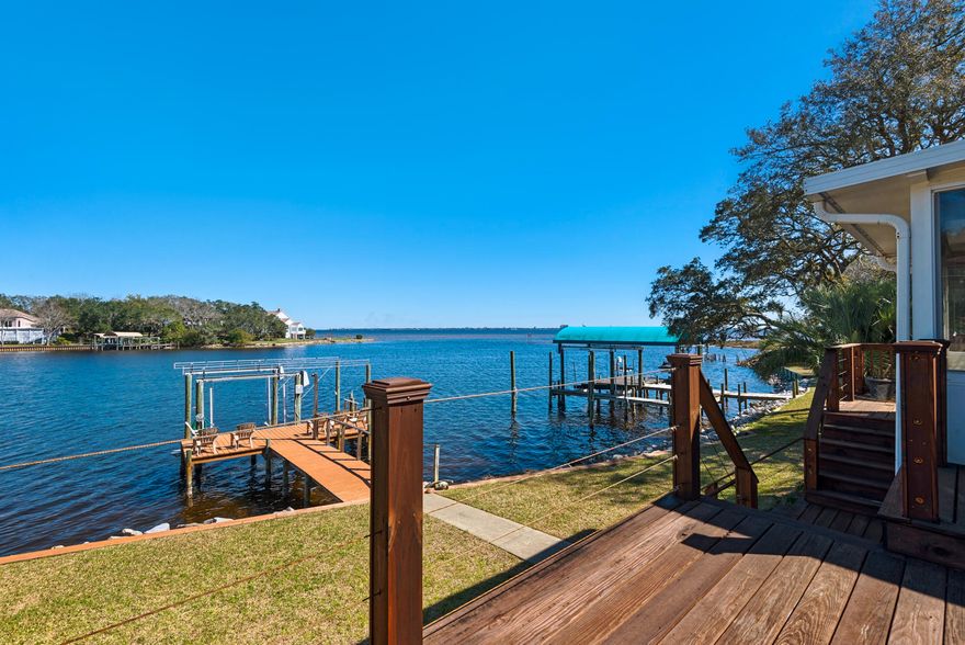 Outstanding, contemporary, updated estate on the shores of Lake Lorraine offers one-of-a-kind views of the lake and Choctawhatchee Bay. Down the winding roads of Lake Pointe, you arrive at this modern champion of a home. Just past the lush, mature landscaping you arrive to a welcoming entry with new front door, freshly painted exterior, and new exterior lighting. As you enter, the grand foyer leads you into the great room that is flooded with natural light that fills the space all the way up to the cathedral ceilings. Views of the water entice you to the sunroom or main level wrap-around deck where you will find plenty of room to grill, dine, lounge, or watch the boats cruise by. From the deck, you'll find protected outdoor space within the screened porch while back inside,