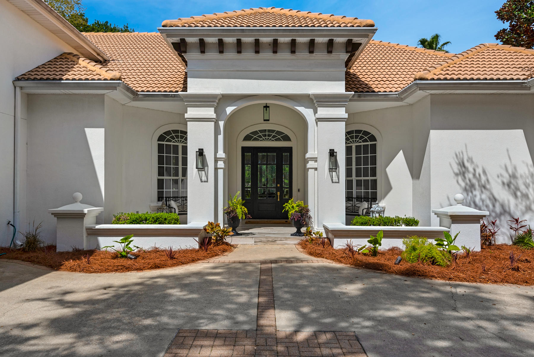 Elegantly designed and primely positioned on a rare, waterfront, oversized corner lot, this modern infused coastal retreat offers a luxurious ownership experience within the gated golf community of Regatta Bay. Natural light flows throughout the five bedroom home thanks to tall windows and raised ceilings, crafting a relaxing atmosphere around every corner of the property. Designer finishes are found throughout, including a one-of-a kind, hand-blown Murano chandelier imported from Italy, quartz countertops, and professional grade appliances in the chef's kitchen. A formal dining area and spacious office are ideal entertaining and work spaces, while a large second living area is located upstairs, above the garage, providing additional space for guests or children as a game or theatre room.