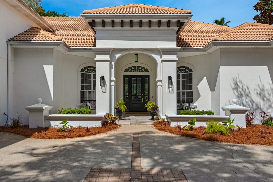 Elegantly designed and primely positioned on a  rare, waterfront, oversized corner lot, this modern infused coastal retreat offers a luxurious ownership experience within the gated golf community of Regatta Bay. Natural light flows throughout the five bedroom home thanks to tall windows and raised ceilings, crafting a relaxing atmosphere around every corner of the property. Designer finishes are found throughout, including a one-of-a kind, hand-blown Murano chandelier imported from Italy, quartz countertops, and professional grade appliances in the chef's kitchen. A formal dining area and spacious office are ideal entertaining and work spaces, while a large second living area is located upstairs, above the garage, providing additional space for guests or children as a game or theatre room.