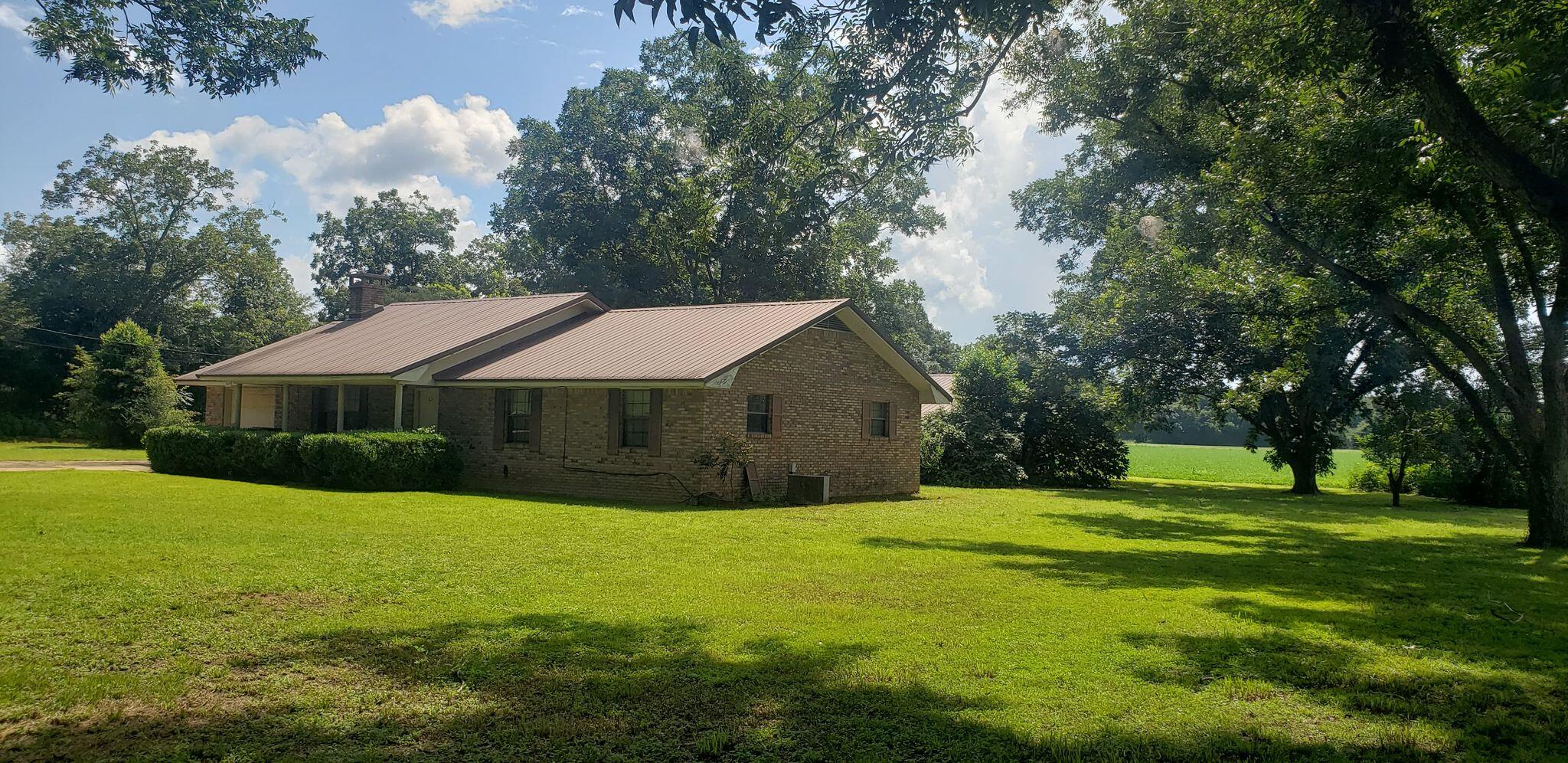 An Acre in Baker!!! Land spreadin' out so far and wide. Keep Manhattan, just give me that countryside. A well built home on 1.11 acres of land surrounded by farm land. If you want a rural setting this is it. This 3 bedroom 2 bath home with a metal roof, a screened patio, an out building with covered area for parties, or parking. Home is in need of some TLC but has so much potential. Nice sized bedrooms and bathrooms. The large living room has built-in shelving and a brick surround and chimney for the wood burning stove. Kitchen has tons of storage and counter space, and so does the adjacent very large laundry room. Newer water heater. Your outdoor country lifestyle and large yard features fig trees, pecan trees, peach trees, and more. Come see this home and make it into your dream ho me in the country. Call your favorite Realtor today for a personal tour.