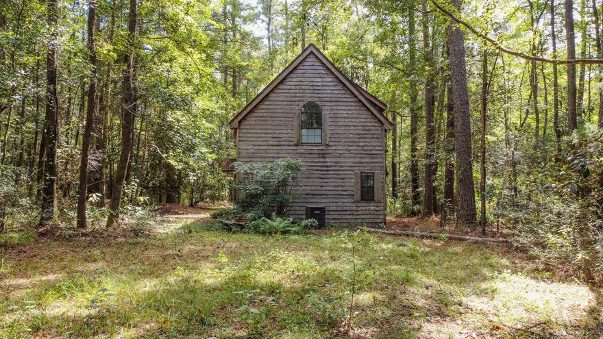 Tucked away on 3+ acres of wooded privacy, this little cabin feels worlds away yet sits just 5 minutes from Walmart and Hwy 331S - and only 35 minutes to the white sandy beaches. Whether you're after a simple cabin retreat (airbnb anyone?!), a rental investment, or a place to live while you dream up your forever home, this one's a find. The upstairs lives like a studio with a full kitchen, walk-in closet, and open living area. The bath has been prepped for renovation after a prior leak was fully remedied. Downstairs, a two-car garage, half bath, and laundry area offer flexible potential as workshop or converted living space. With well-kept neighboring properties, this peaceful retreat offers the quiet of the tall pines, birdsong, and rustling leaves is sure to cure your craving for quiet.
